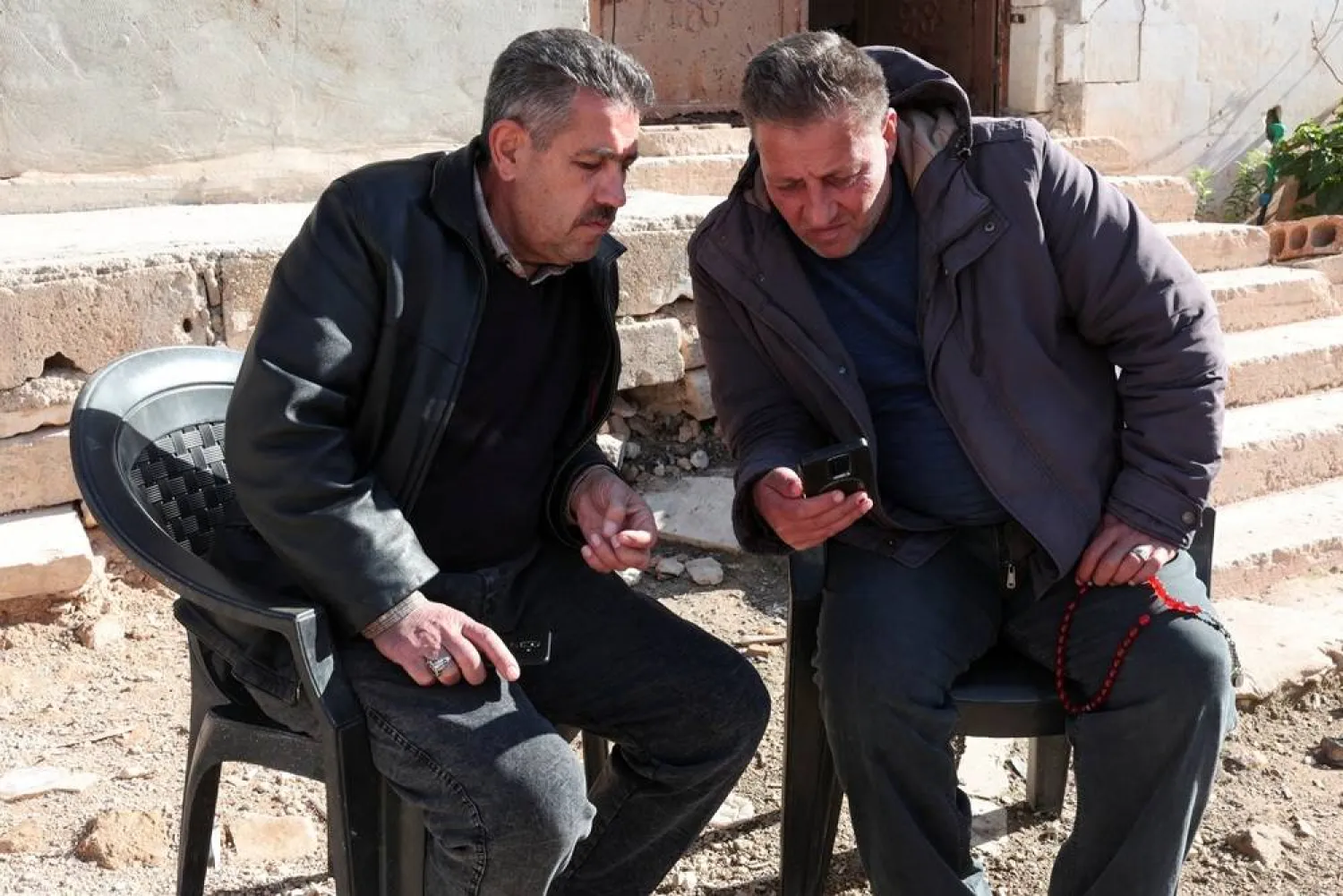  Uncle and cousin of Ahmed al-Ahmed, both named Mohammed al-Ahmed, look at the footage of Ahmed al-Ahmed, the bystander who disarmed a gunman during a shooting at a Hanukkah event at Sydney's Bondi Beach, in the town of Nayrab in the northwestern province of Idlib, Syria, December 16, 2025. (Reuters)