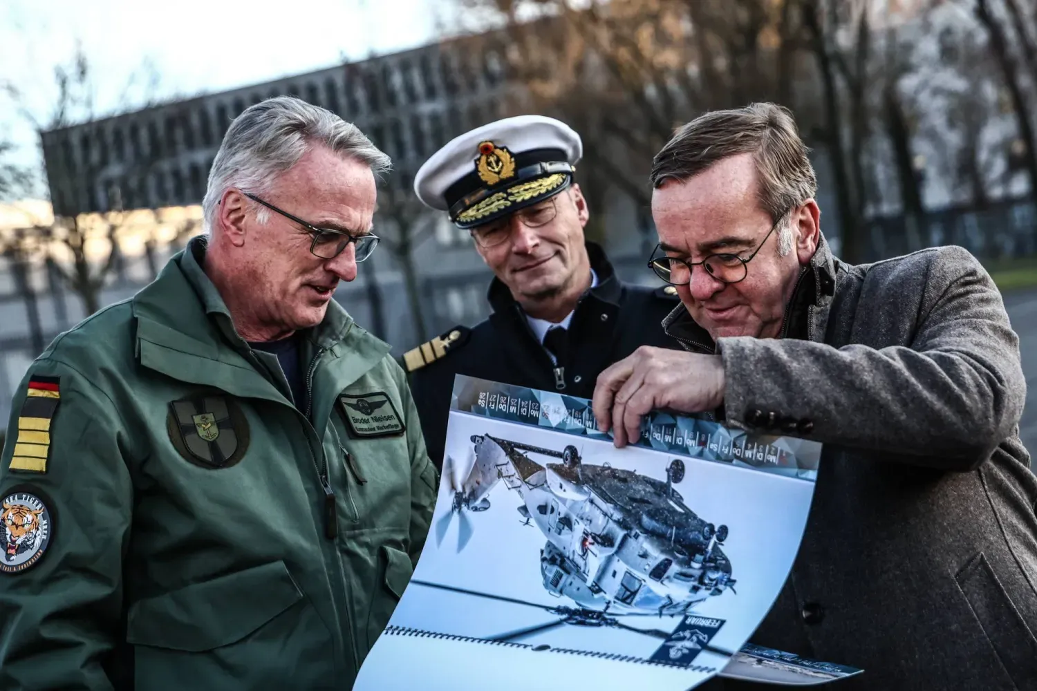 Almanya Savunma Bakanı Boris Pistorius (sağda), Alman Donanma Komutanı Koramiral Jan Christian Kac (ortada) ve Kaptan Bruder Nielsen, Berlin'deki Savunma Bakanlığı'nda düzenlenen bir Sea Tiger helikopterinin teslim töreninde askeri belgeleri inceliyor... 16 Aralık 2025 (EPA)