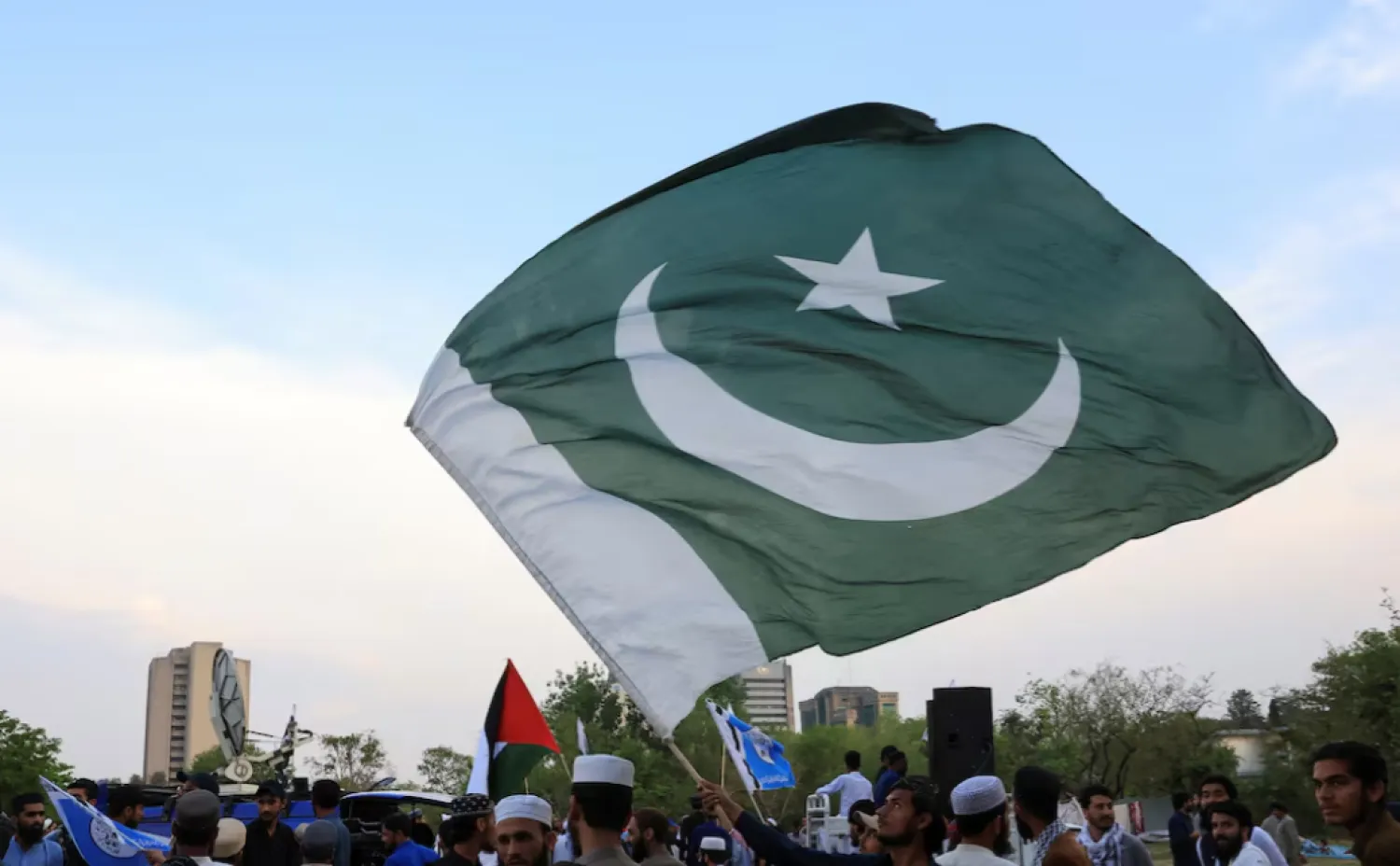 A man waves Pakistan's flag as he along with others gather in support of Pakistan Army, day after the ceasefire announcement between India and Pakistan, in Islamabad, Pakistan, May 11, 2025. REUTERS/Akhtar Soomro 