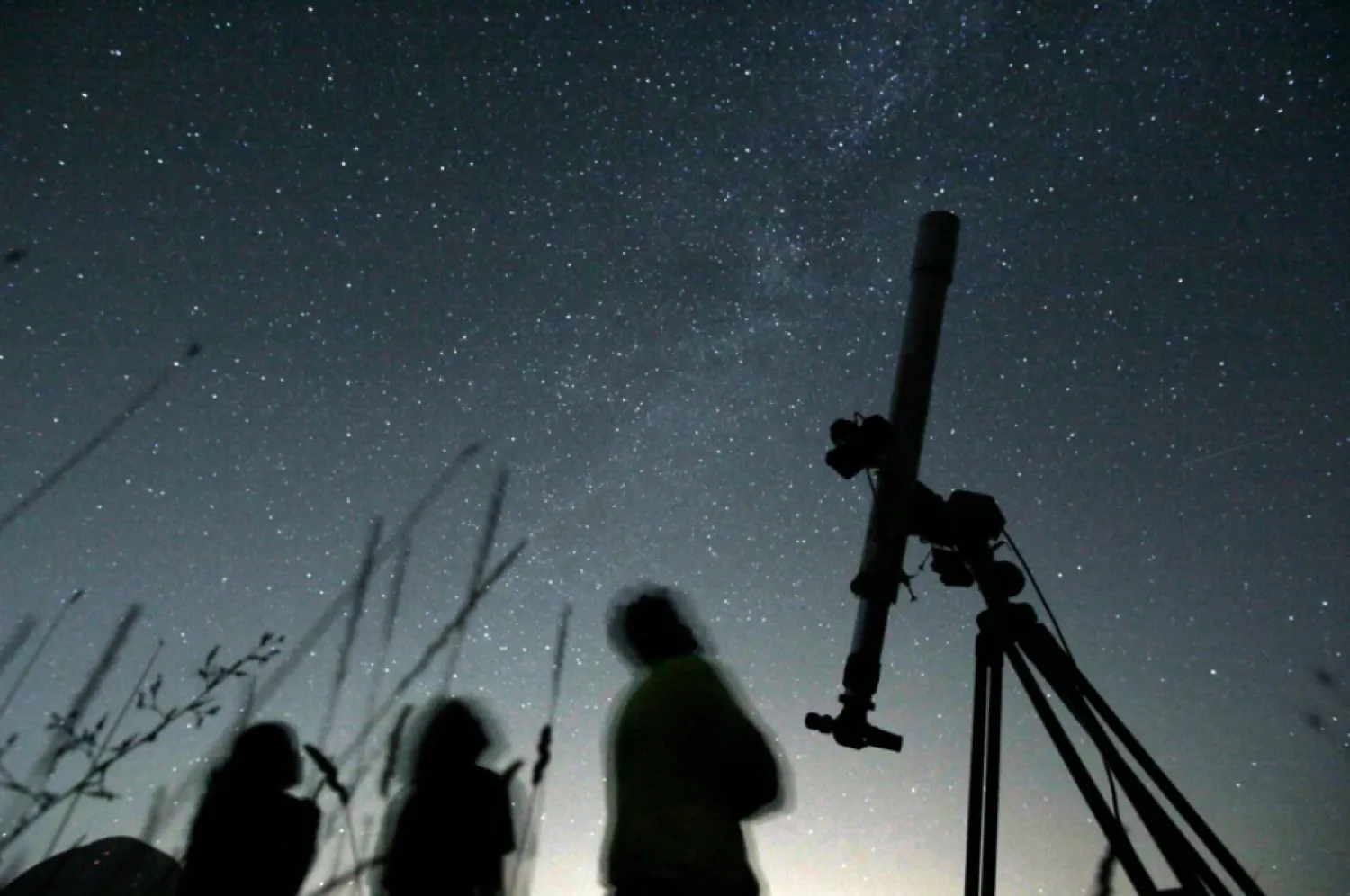 People look up to the sky from an observatory near the village of Avren, Bulgaria, Aug. 12, 2009. (AP Photo/Petar Petrov, File)

