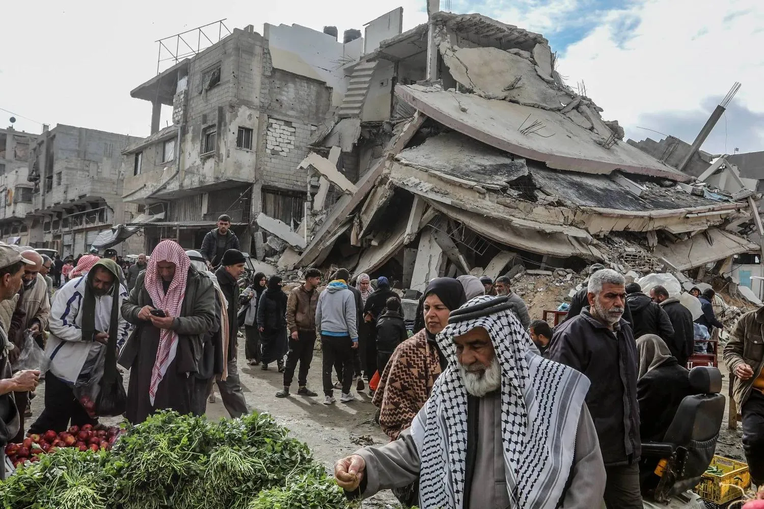 Palestinians shop amid the rubble in Khan Younis in southern Gaza, February last year (DPA)