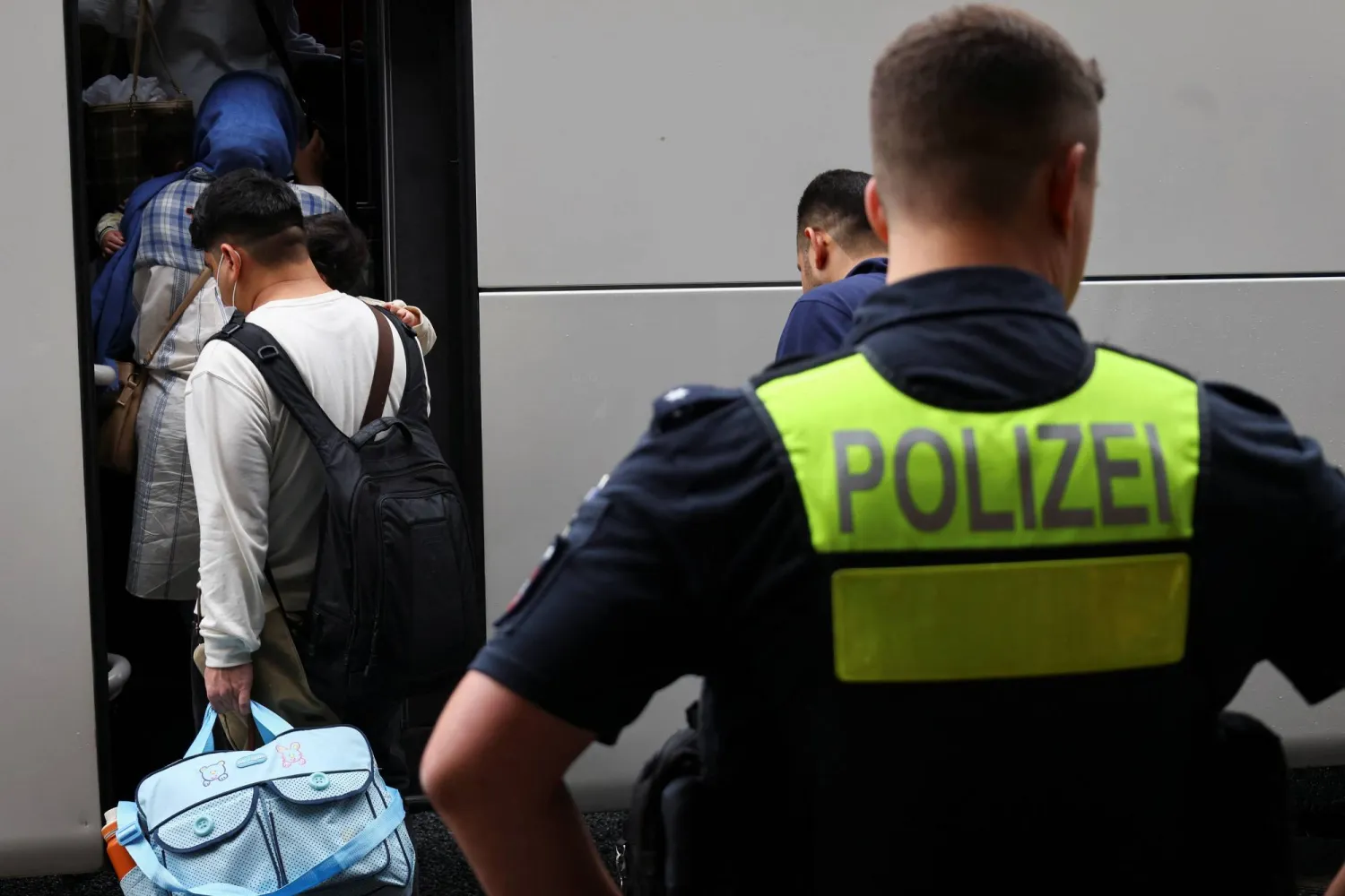 أفغان يدخلون حافلة بمطار هانوفر فور وصولهم إلى ألمانيا بعد منحهم حق اللجوء فيها (أرشيفية - رويترز)