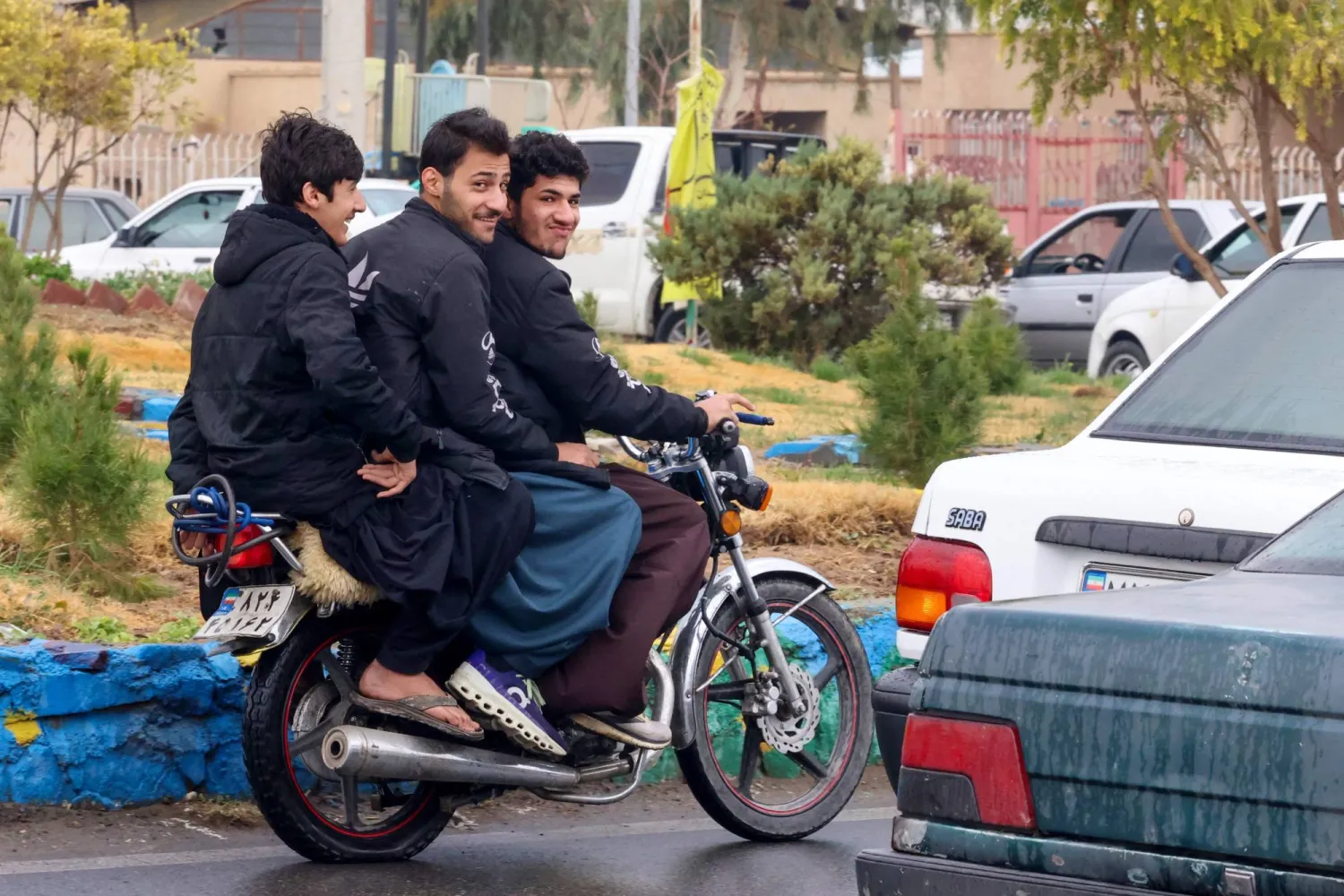 Baluch Iranian youths ride on a motorcycle in Zahedan, in the southeastern province of Sistan-Baluchistan bordering Afghanistan on December 18, 2025. (Photo by ATTA KENARE / AFP)