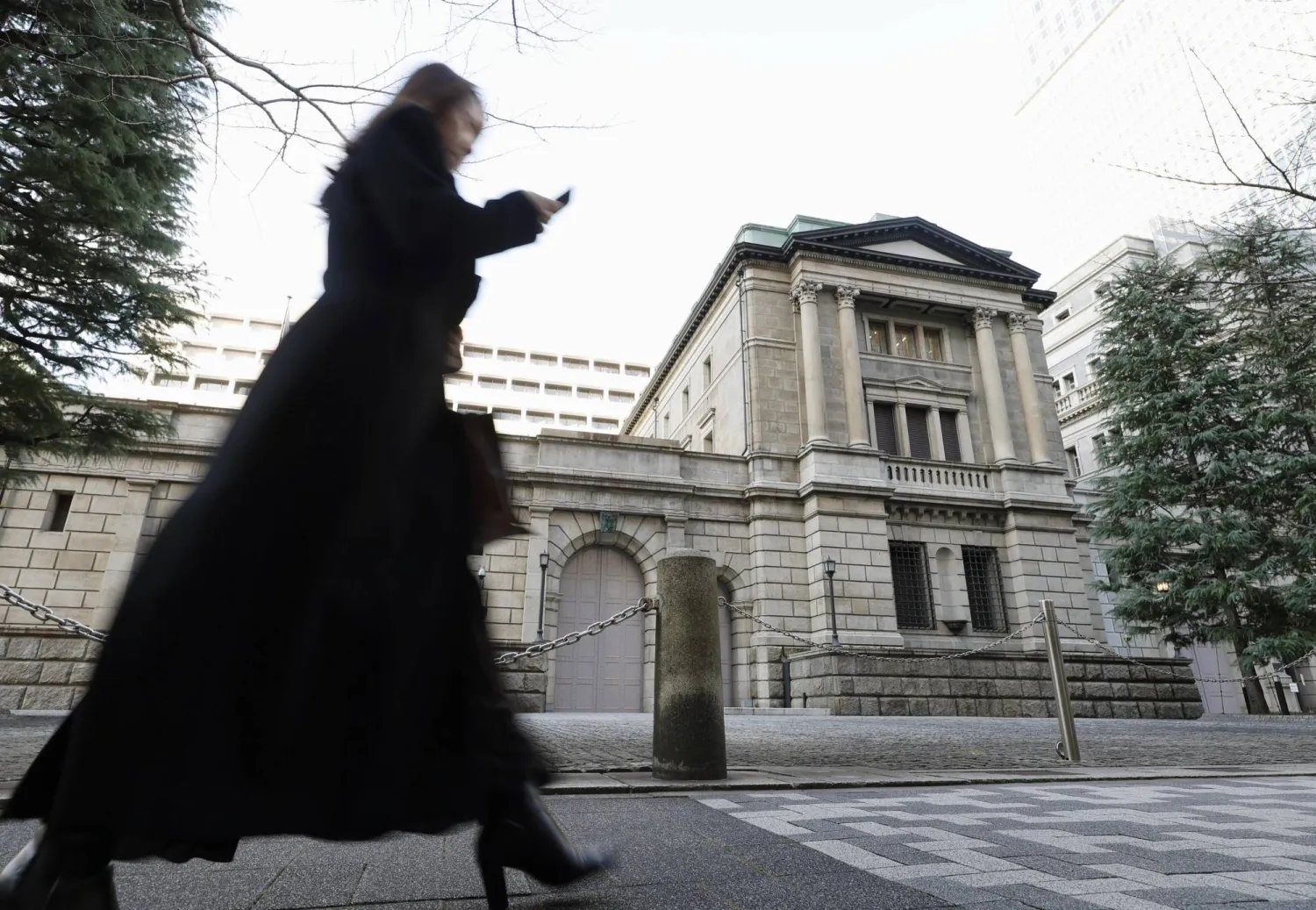 سيدة تمر أمام مقر بنك اليابان المركزي في وسط العاصمة طوكيو (أ.ب)