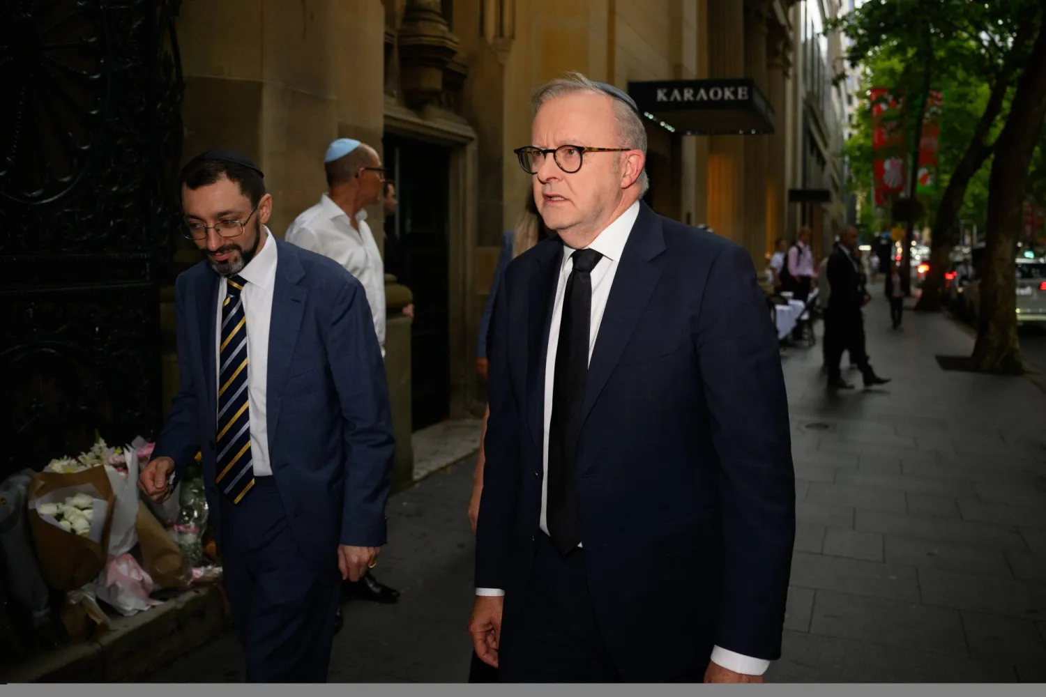 الحاخام بنيامين إلتون (يسار) يستقبل رئيس الوزراء الأسترالي أنتوني ألبانيز (يمين) لدى وصوله إلى الكنيس الكبير في سيدني بأستراليا 19 ديسمبر(رويترز)