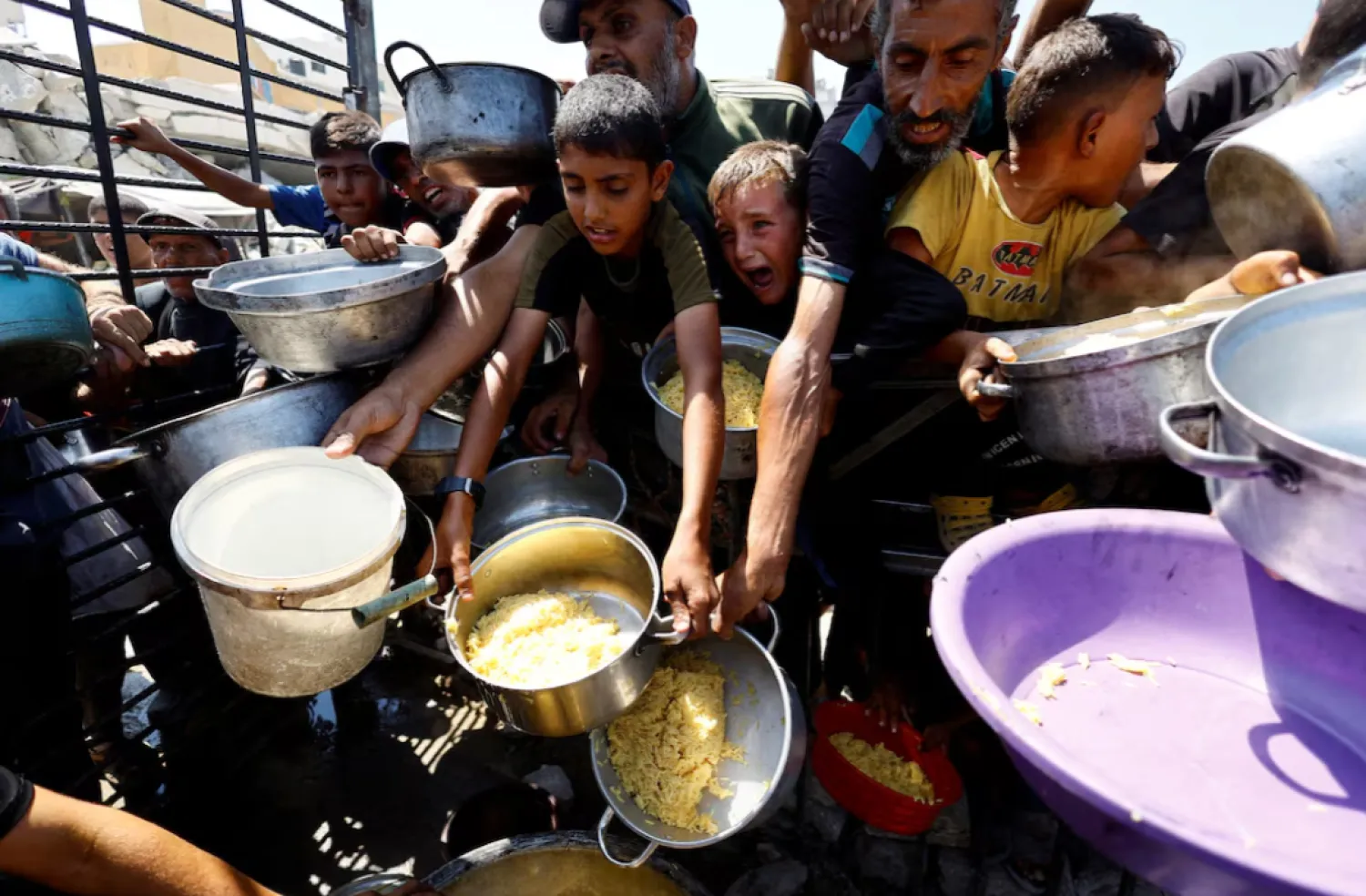 Palestinians wait to receive food from a charity kitchen after the global hunger monitor, in Gaza City, August 28, 2025. REUTERS/Mahmoud Issa/File Photo