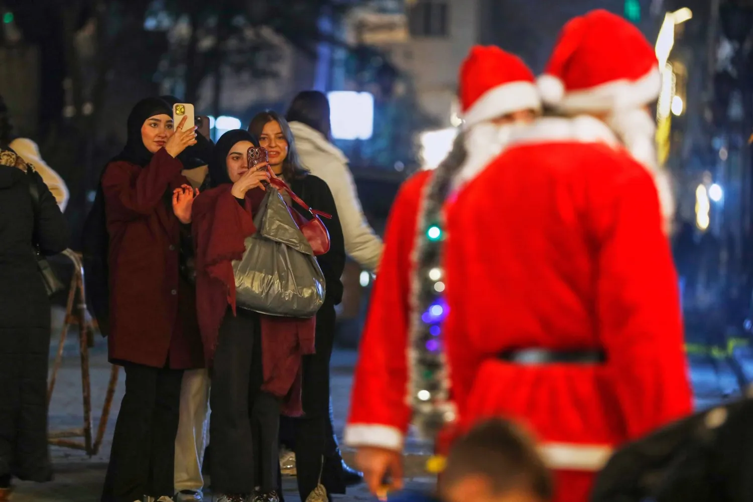 رجلان يرتديان زي سانتا كلوز في أحد شوارع دمشق (أ.ب)