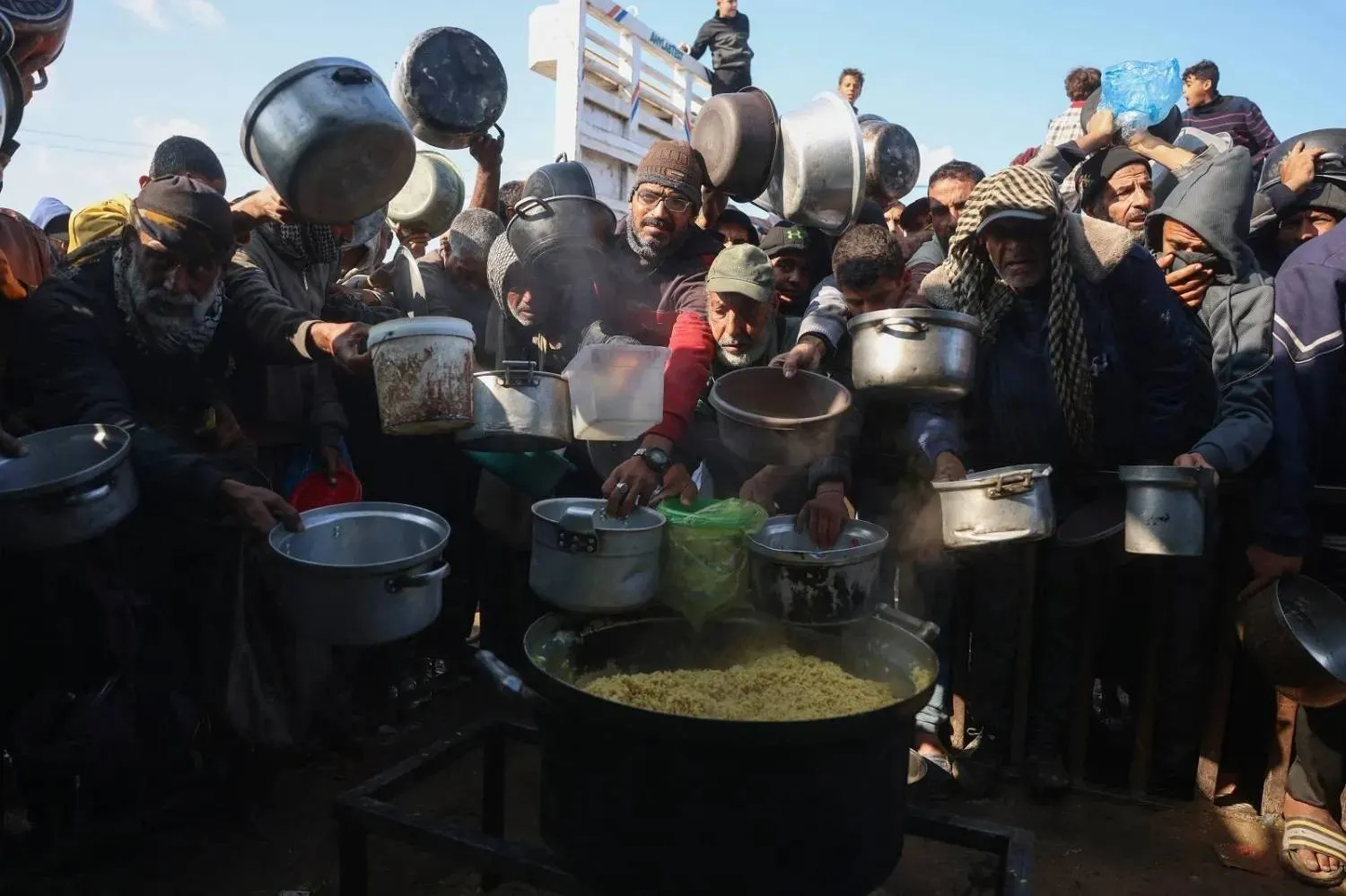 Displaced Palestinians gather to receive food rations at a charity kitchen in Khan Younis, southern Gaza (AFP)
