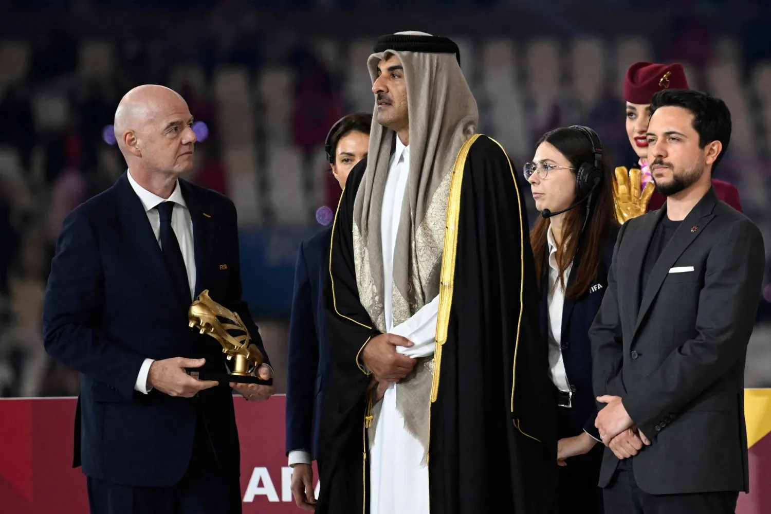 FIFA President Gianni Infantino (L), and Qatar Emir Sheikh Tamim bin Hamad Al-Thani (C) and Jordan's Crown Prince Hussein stand on the podium for the awards ceremony after the FIFA Arab Cup 2025 final football match between Jordan and Morocco at the Lusail Stadium Stadium, in Lusail on December 18, 2025. (Photo by Mahmud HAMS / AFP)
