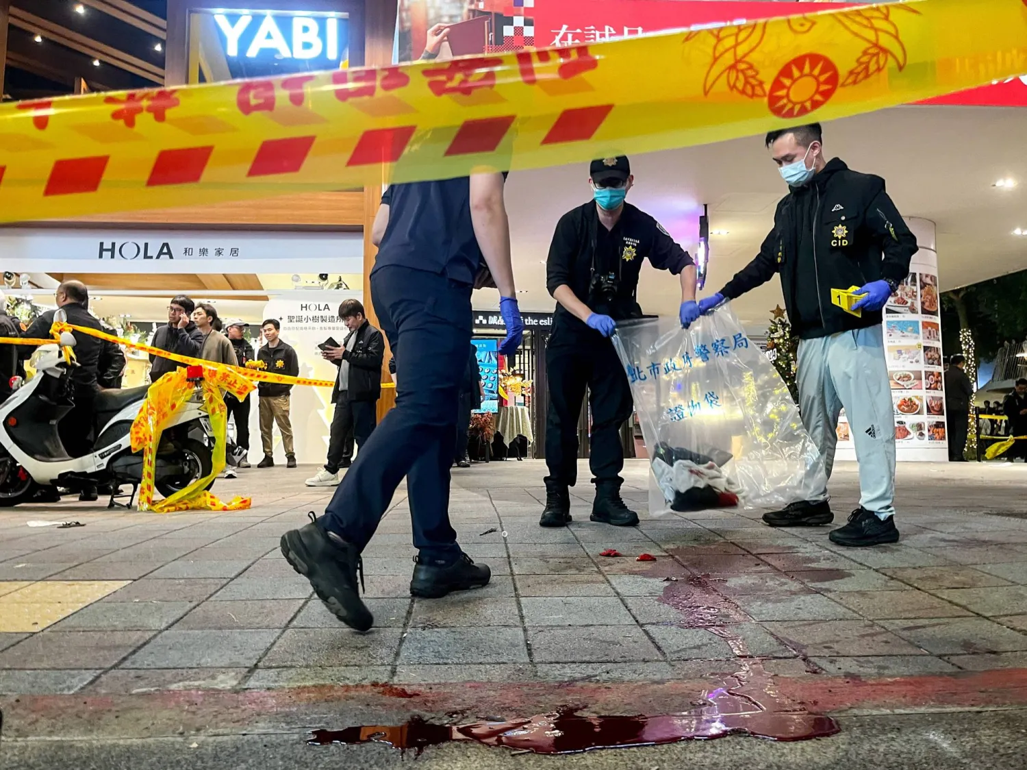 Police collect evidence from a crime scene outside Eslite Spectrum Nanxi store near Zhongshan station as the entrance of the building is cordoned off with yellow crime scene tape, in Taipei, Taiwan, December 19, 2025. REUTERS/Ann Wang