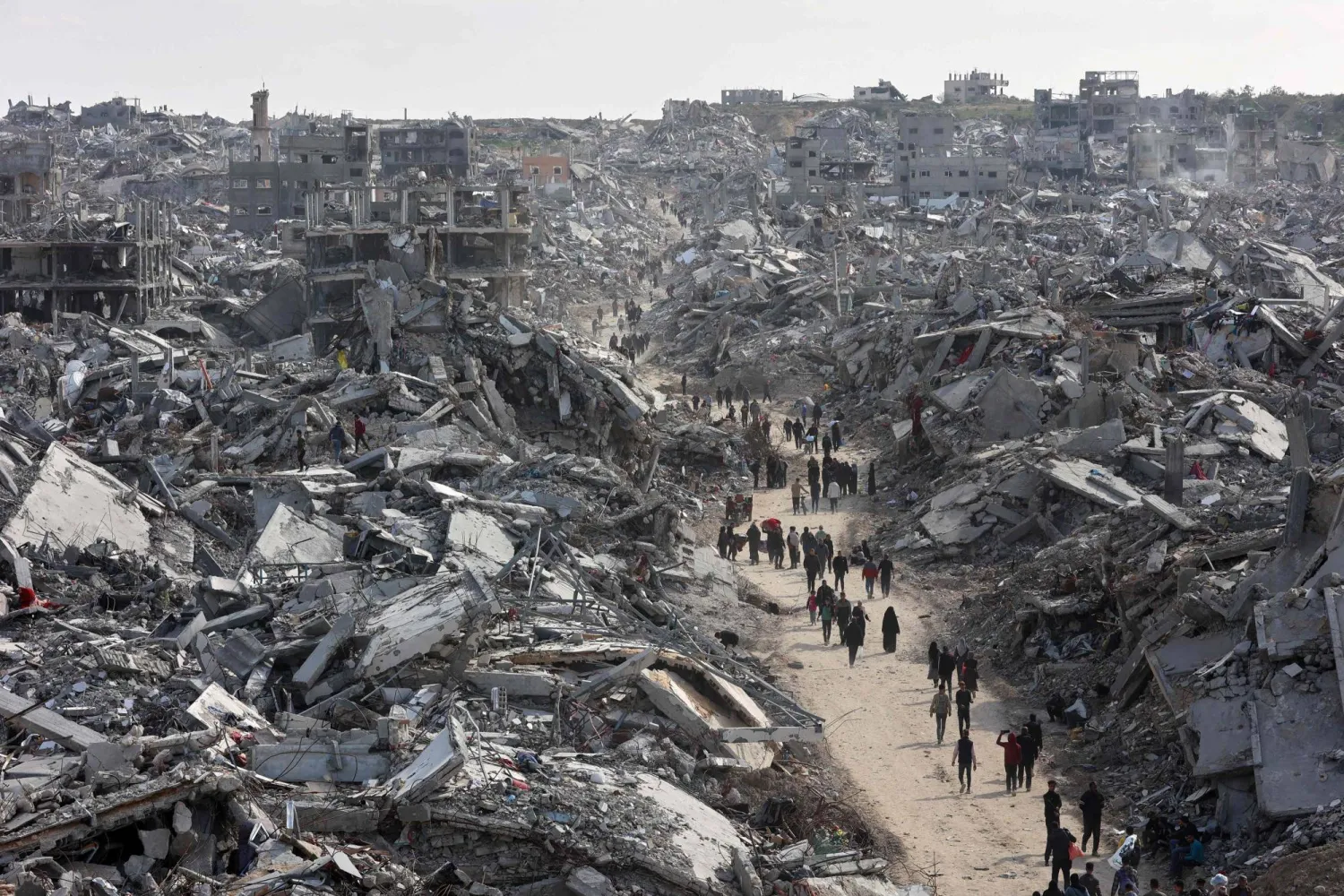 (FILES) This aerial view shows displaced Palestinians returning to the war-devastated Jabalia refugee camp in the northern Gaza Strip on January 19, 2025, shortly before a ceasefire deal in the war between Israel and Hamas was implemented. (Photo by Omar AL-QATTAA / AFP)