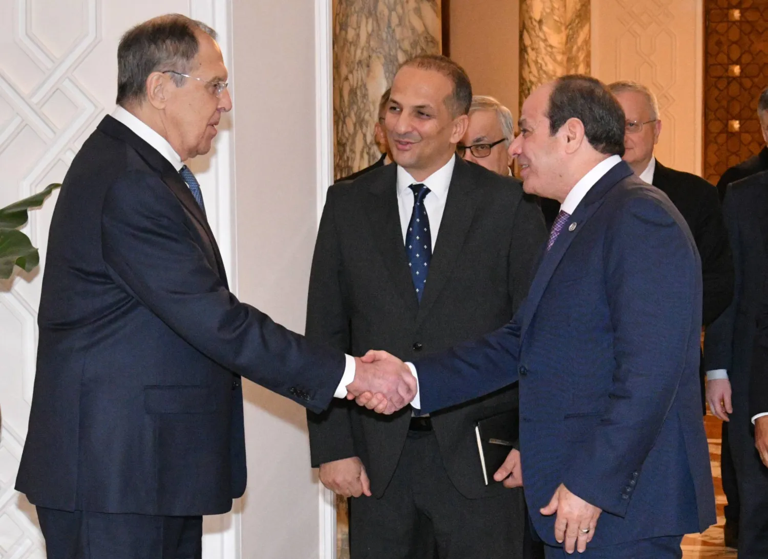 In this photo, provided by Egypt's presidency media office, Egyptian President Abdel-Fattah el-Sisi, front right, greets Russian Foreign Minister Sergei Lavrov, left, before their meeting at the Presidential Palace in Cairo, Egypt, Saturday, Dec. 20, 2025. (Egyptian Presidency Media Office via AP)