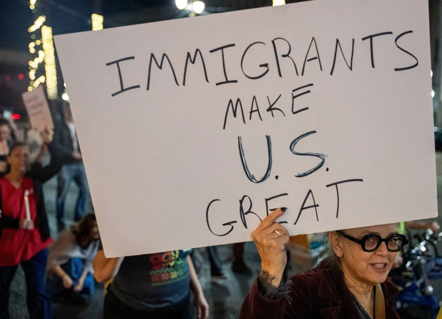 A woman holds a poster as immigrants rights activists stage a traditional Mexican posada, reenacting Mary and Joseph’s search for shelter, to symbolize immigrants seeking refuge from Immigration and Customs Enforcement (ICE) agents during the ongoing immigration operation "Catahoula Crunch", in New Orleans, Louisiana, US, December 18, 2025. REUTERS/Seth Herald