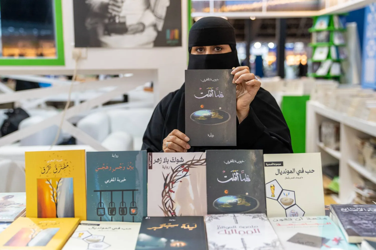 الكاتبة خيرية المغربي مع إصداراتها الأدبية (الشرق الأوسط)