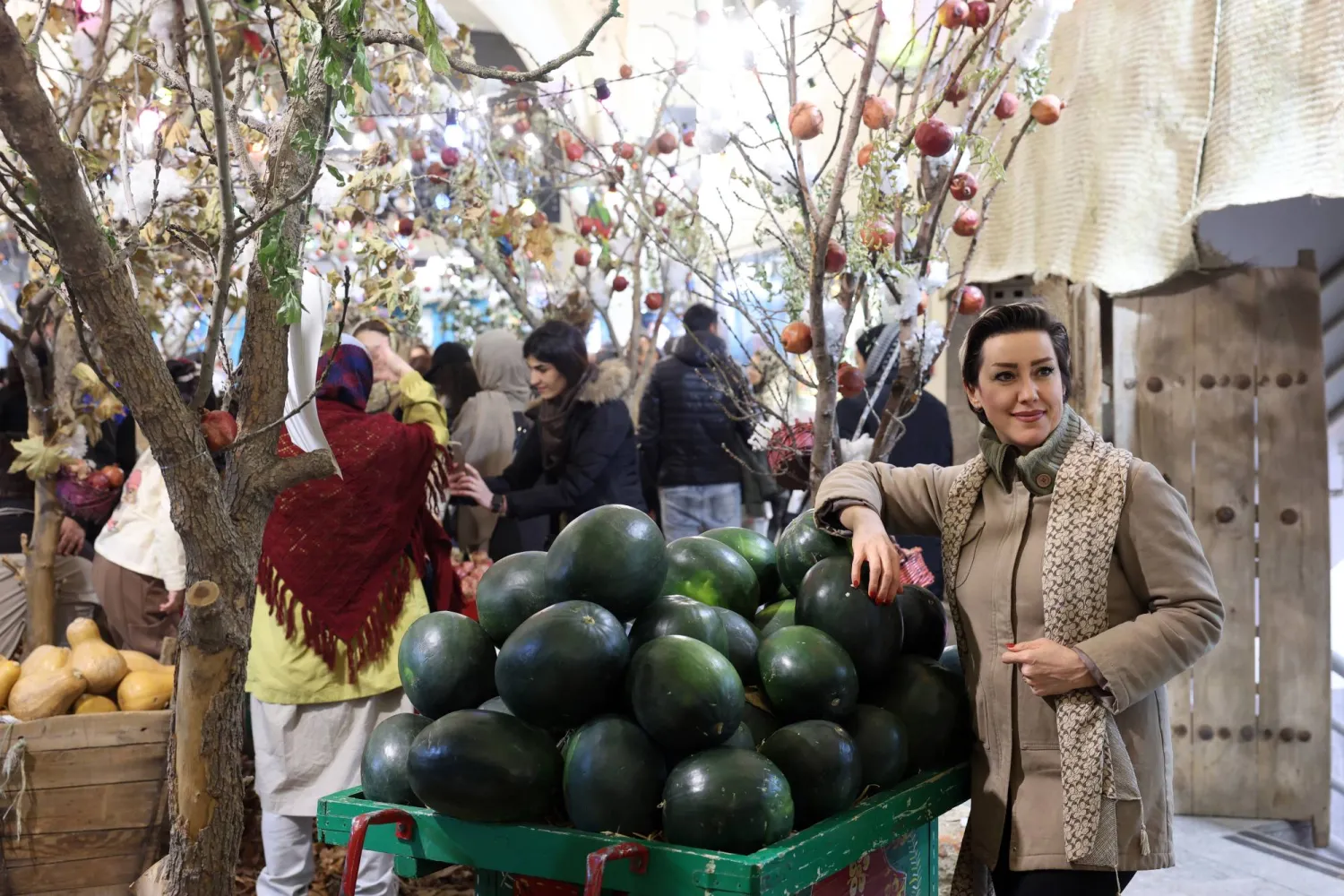 امرأة إيرانية تلتقط صورة وهي تحمل بطيخة فيما يستعد الإيرانيون للاحتفال بعيد «يلدا» (إ.ب.أ)