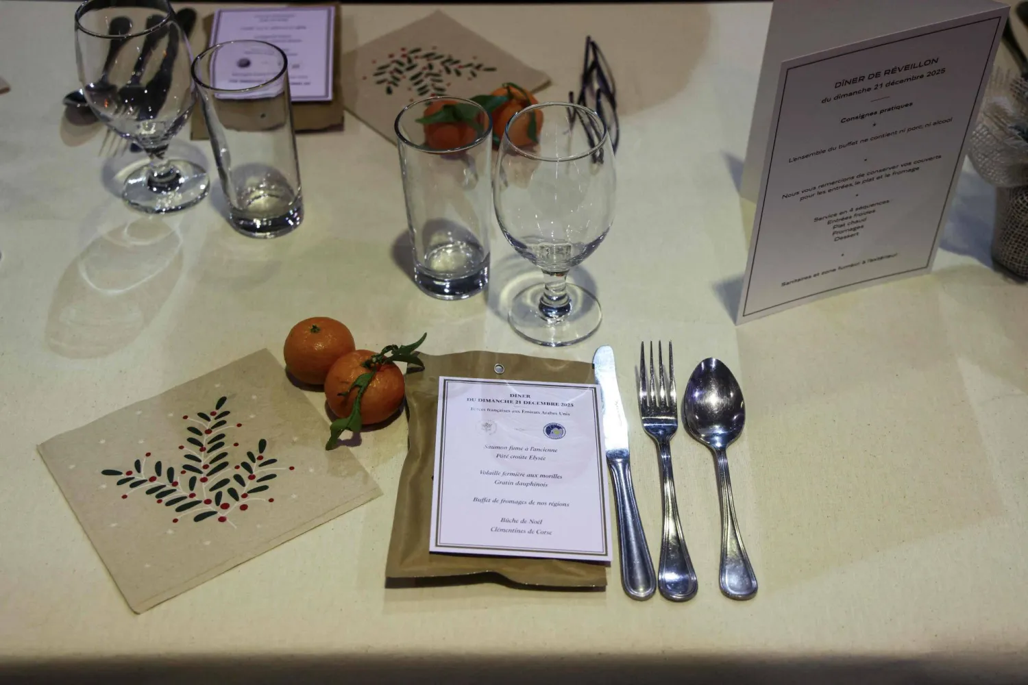 أدوات مائدة وقائمة طعام في انتظار حضور الرئيس الفرنسي إيمانويل ماكرون لعشاء الكريسماس مع جنوده في أبوظبي (أ.ف.ب)