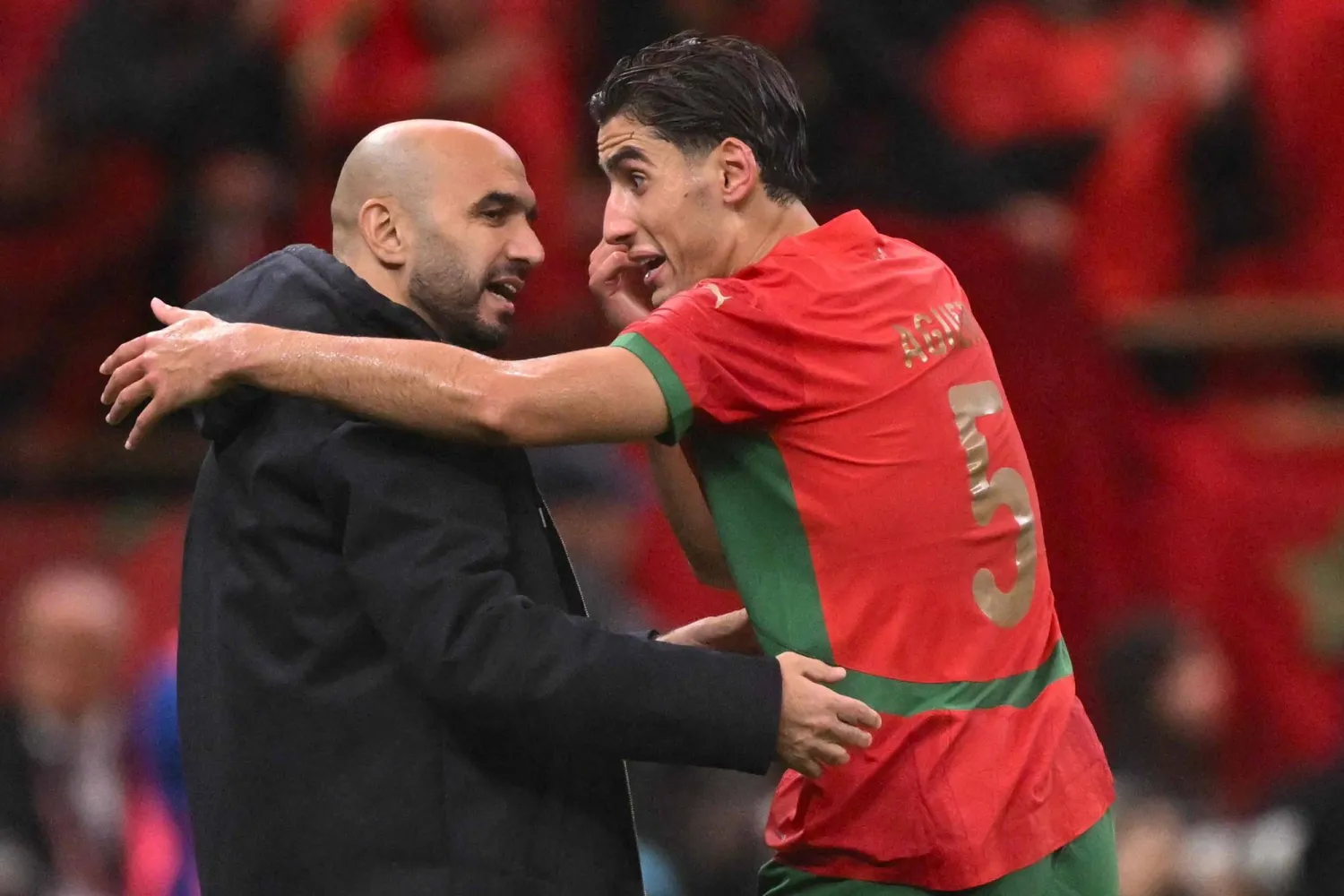 وليد الركراكي مدرب المغرب مع لاعبه نايف أغرد (أ.ف.ب)