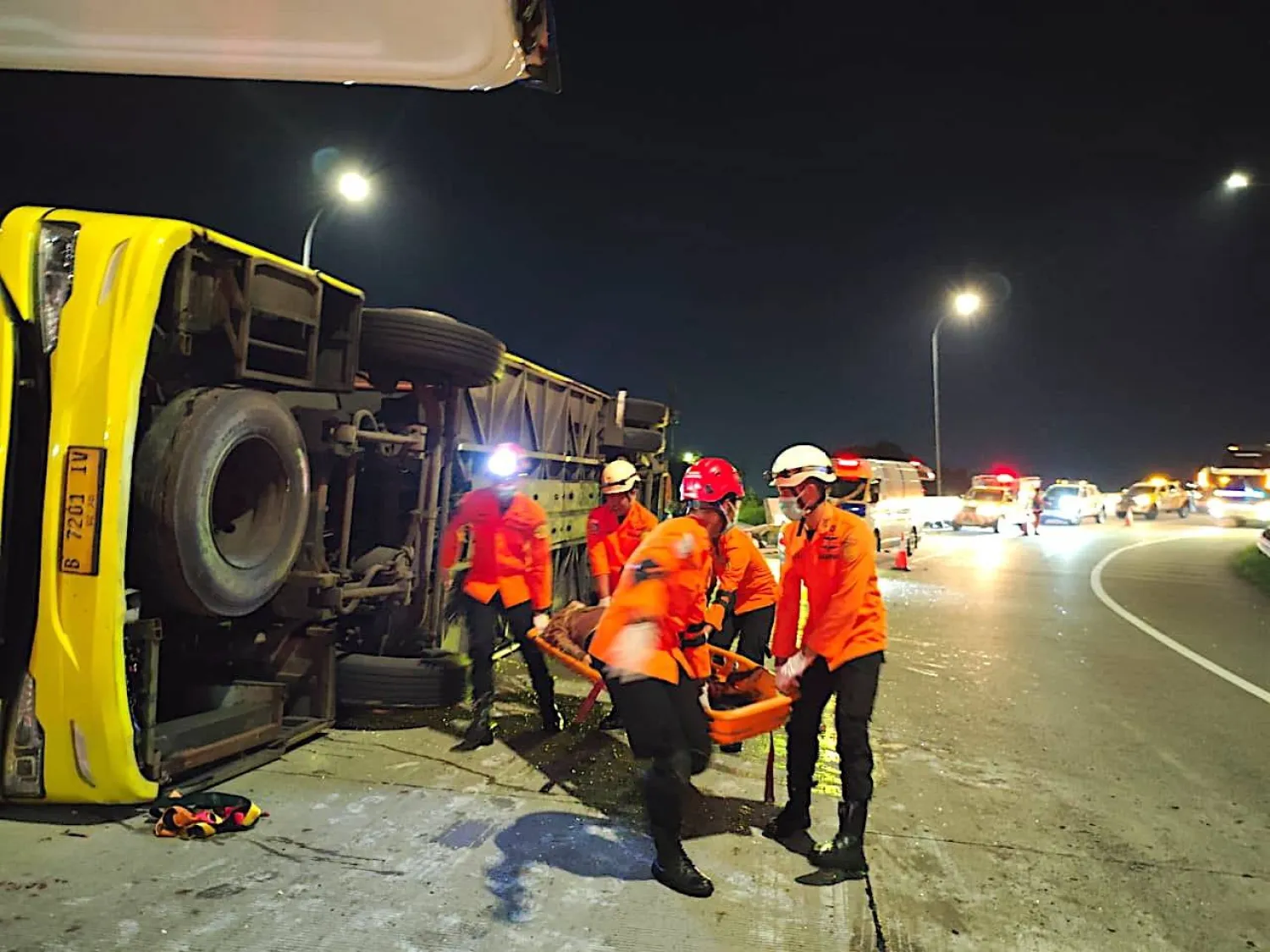A handout photo made available by the Indonesian National Search and Rescue Agency (BASARNAS) shows rescuers carrying a survivor from the wreckage of a crashed bus in Semarang, Central Java, Indonesia, 22 December 2025. (EPA/BASARNAS/Handout) 