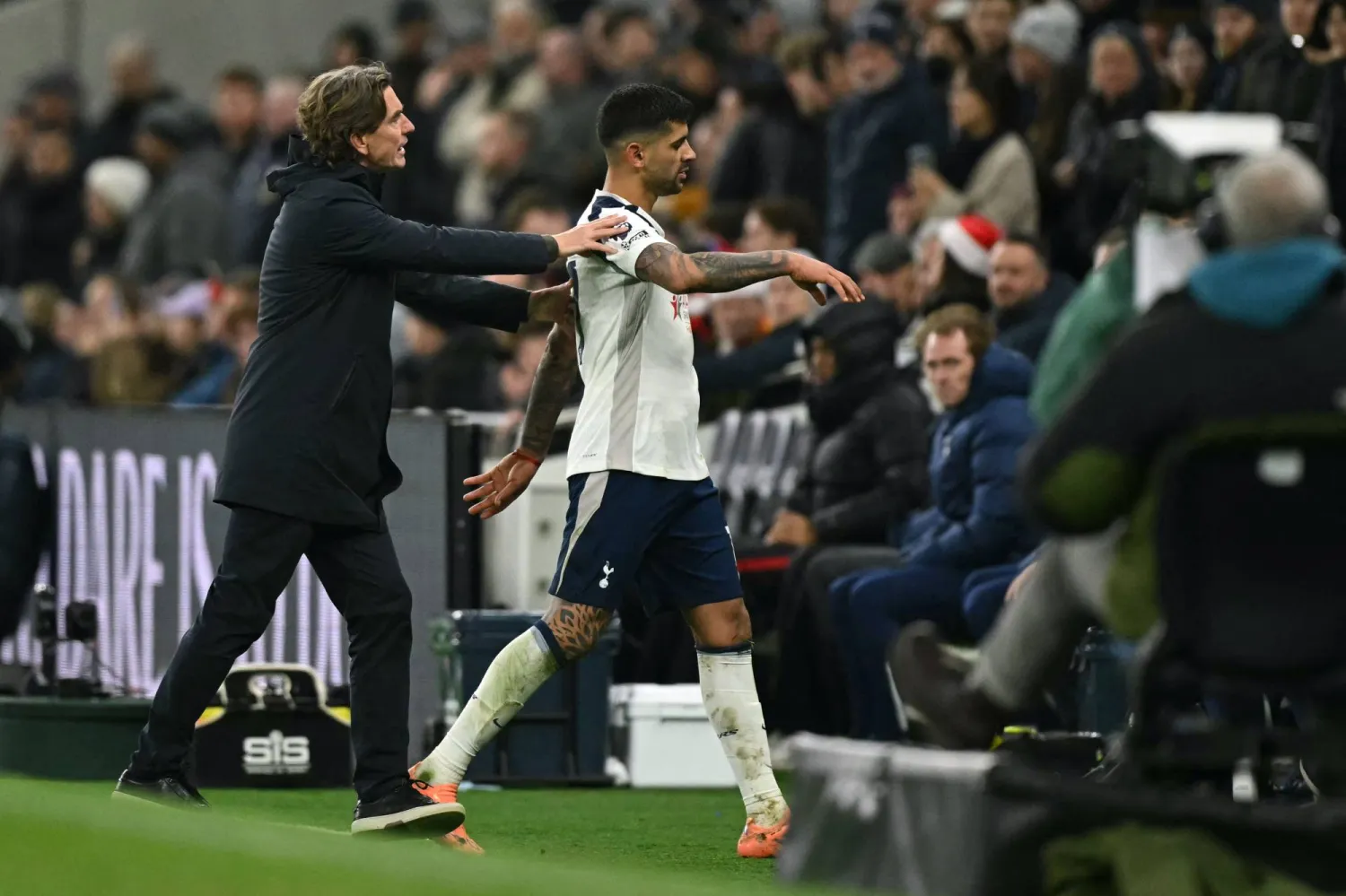 Tottenham Hotspur's Argentinian defender #17 Cristian Romero is ushered off the pitch by Tottenham Hotspur's Danish head coach Thomas Frank after becoming the second Tottenham player sent off during the English Premier League football match between Tottenham Hotspur and Liverpool at the Tottenham Hotspur Stadium in London, on December 20, 2025. (AFP)