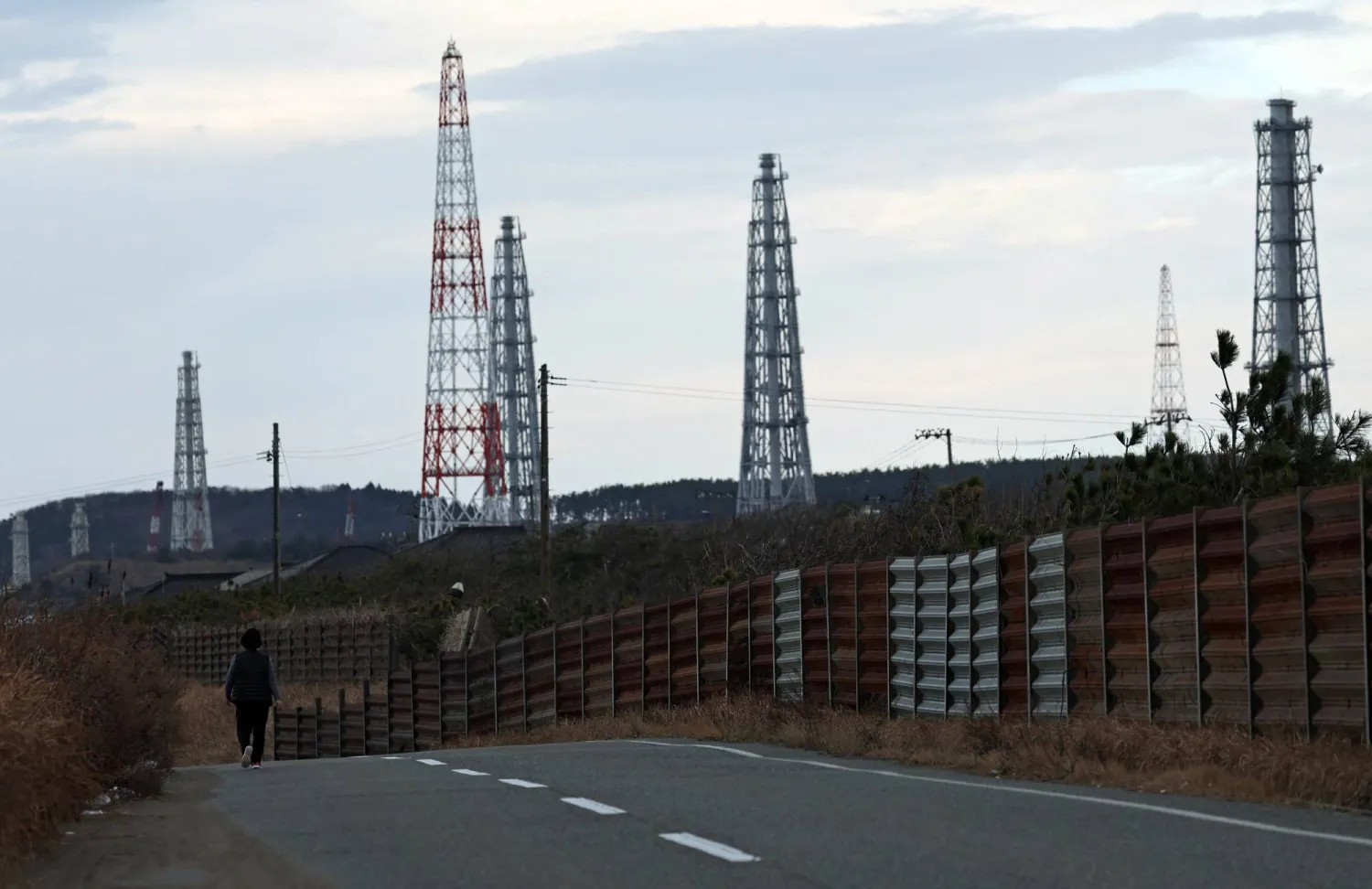 رجل يمر في طريق قرب محطة كاشيوازاكي - كاريوا الكهربائية النووية شمال غربي العاصمة اليابانية طوكيو (رويترز)