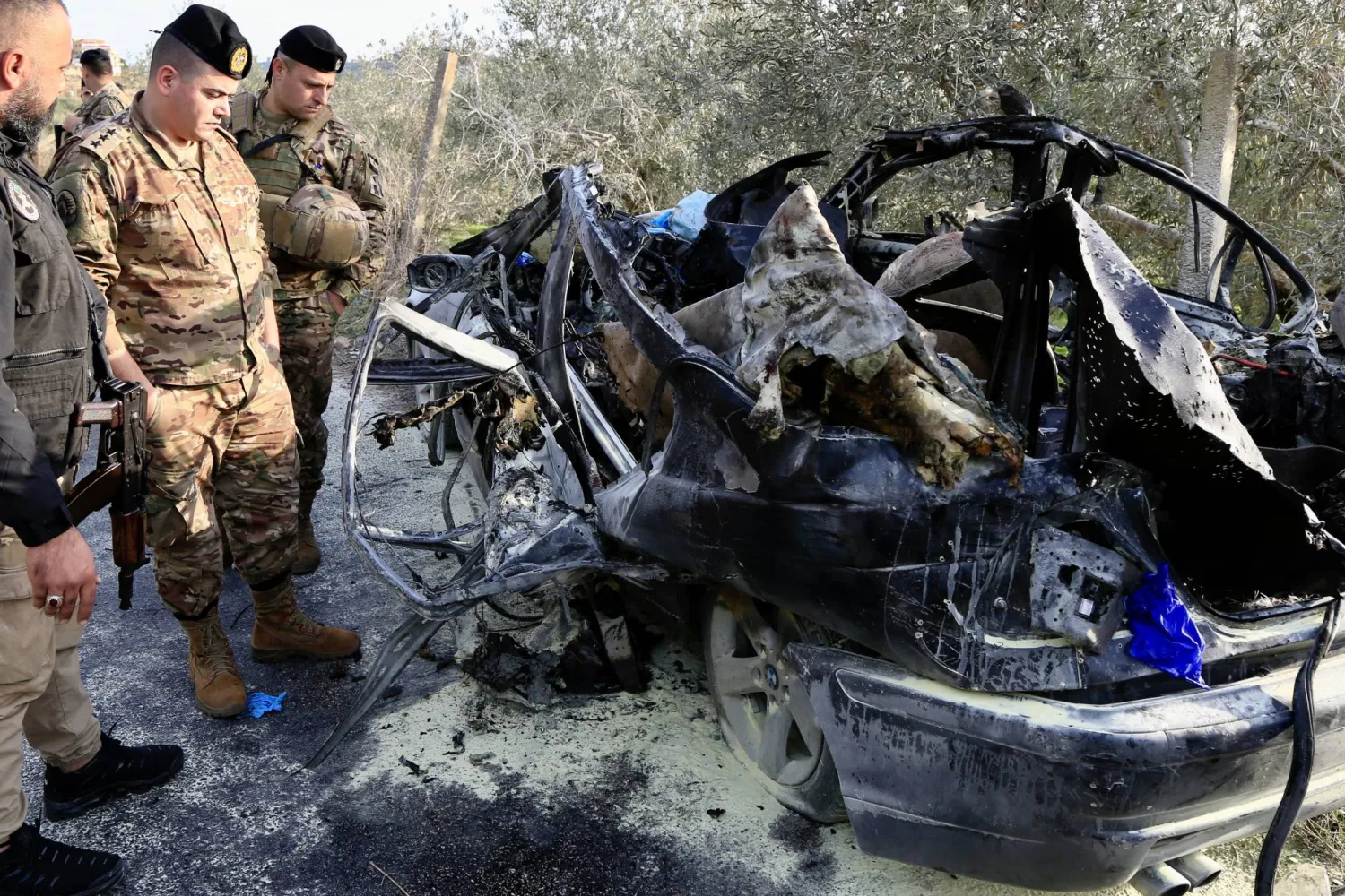 عناصر من الجيش اللبناني يعاينون السيارة التي تم استهدافها في بلدة عتقنيت (قضاء صيدا) وأدت إلى مقتل 3 أشخاص بينهم عنصر بالجيش اللبناني (إ.ب.أ)