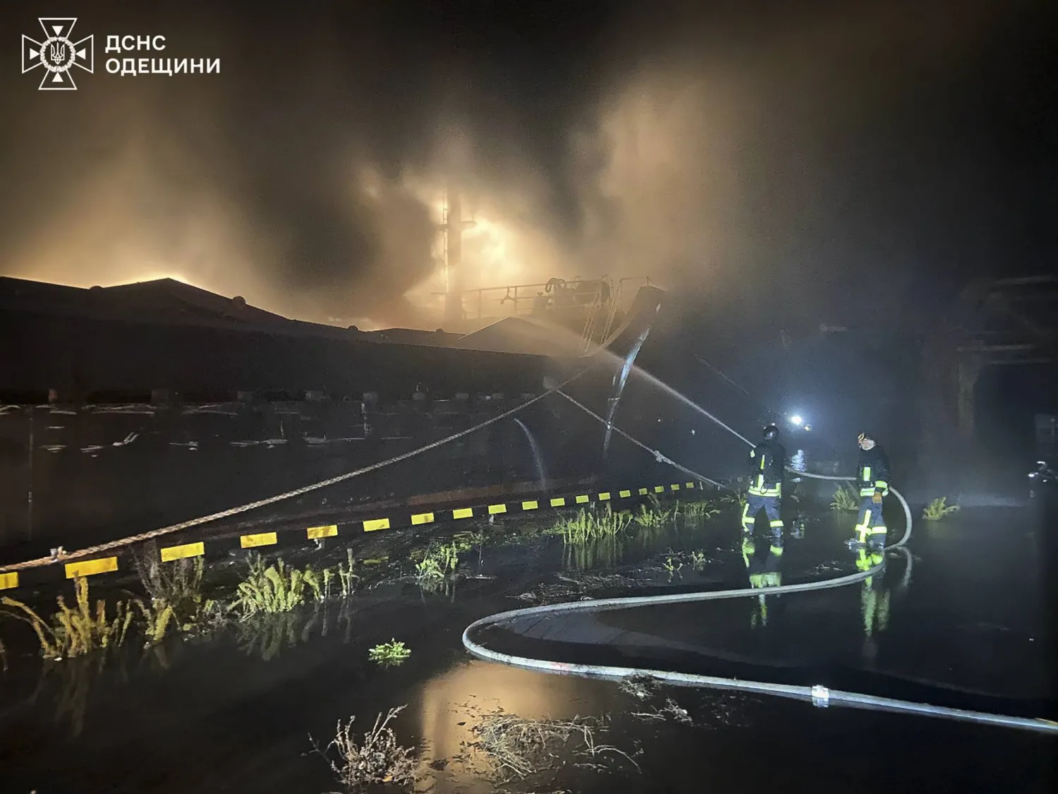 رجال إطفاء يعملون على إخماد حريق جراء قصف روسي على مرفأ في منطقة أوديسا الأوكرانية الثلاثاء (إ.ب.أ)