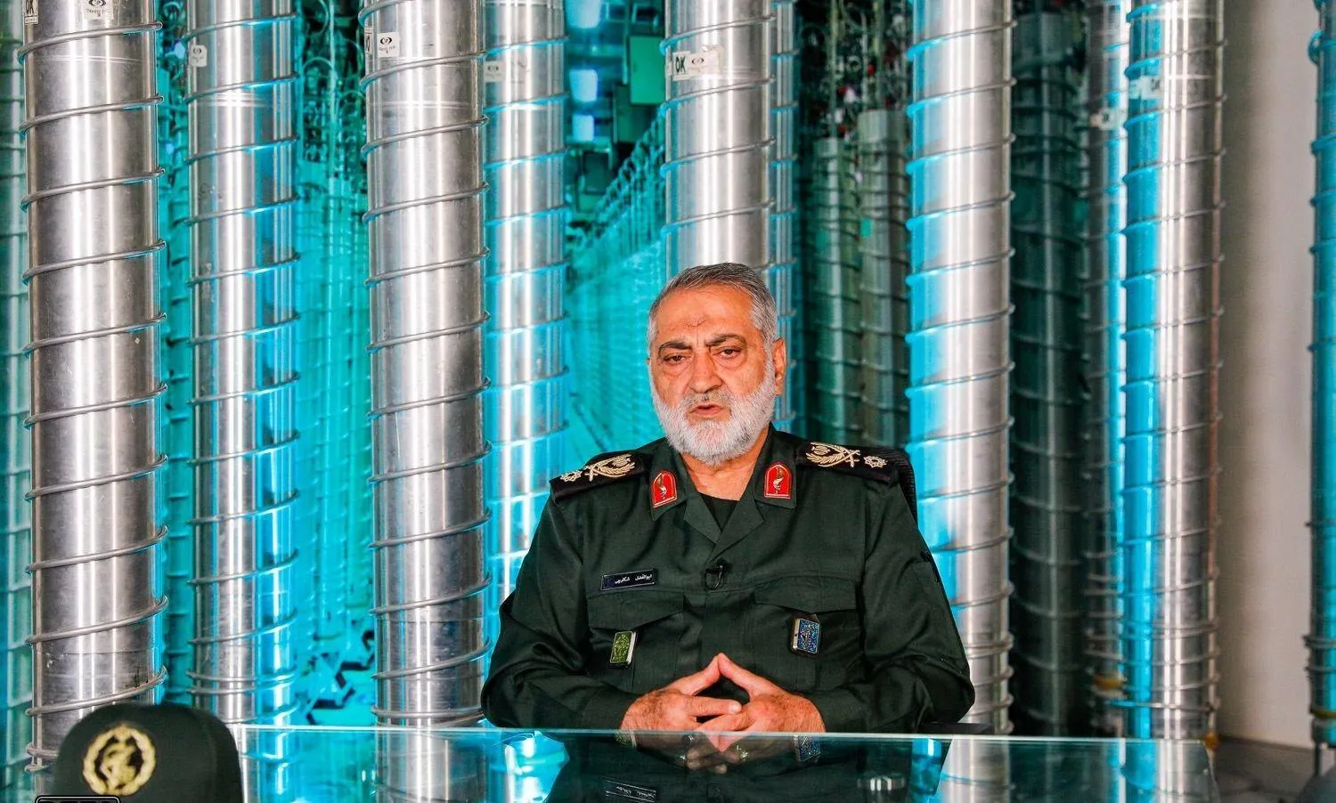 المتحدث باسم القوات المسلحة الإيرانية أبو الفضل شكارجي خلال حوار ويبدو خلفه ملصق لأجهزة الطرد المركزي (دفاع برس)