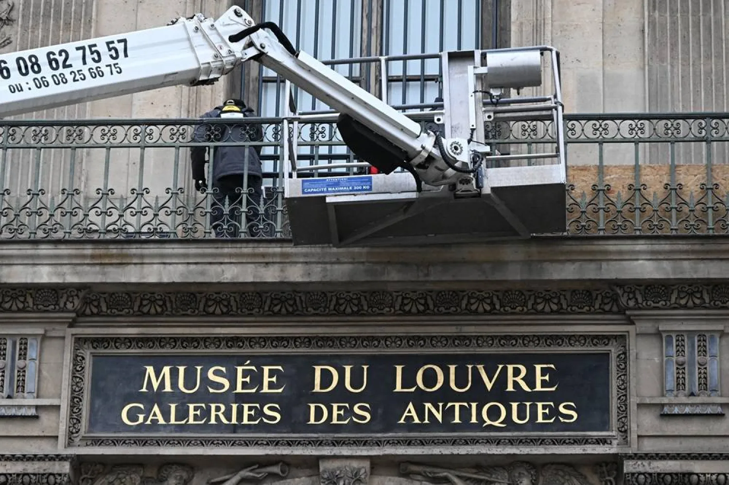  Workers install metal security bars over the window where thieves broke into the Louvre museum on Oct.19, Tuesday Dec.23, 2025 in Paris. (AP) 