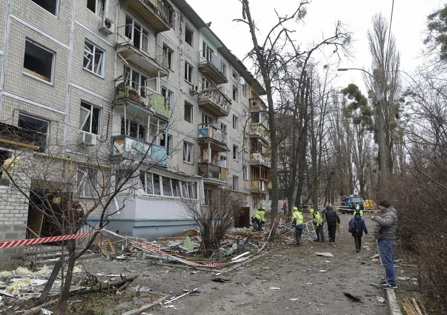Ukrainian communal workers clean debris at the site of a Russian drone strike on a five-story residential building in Kyiv, Ukraine, 23 December 2025. (EPA) 