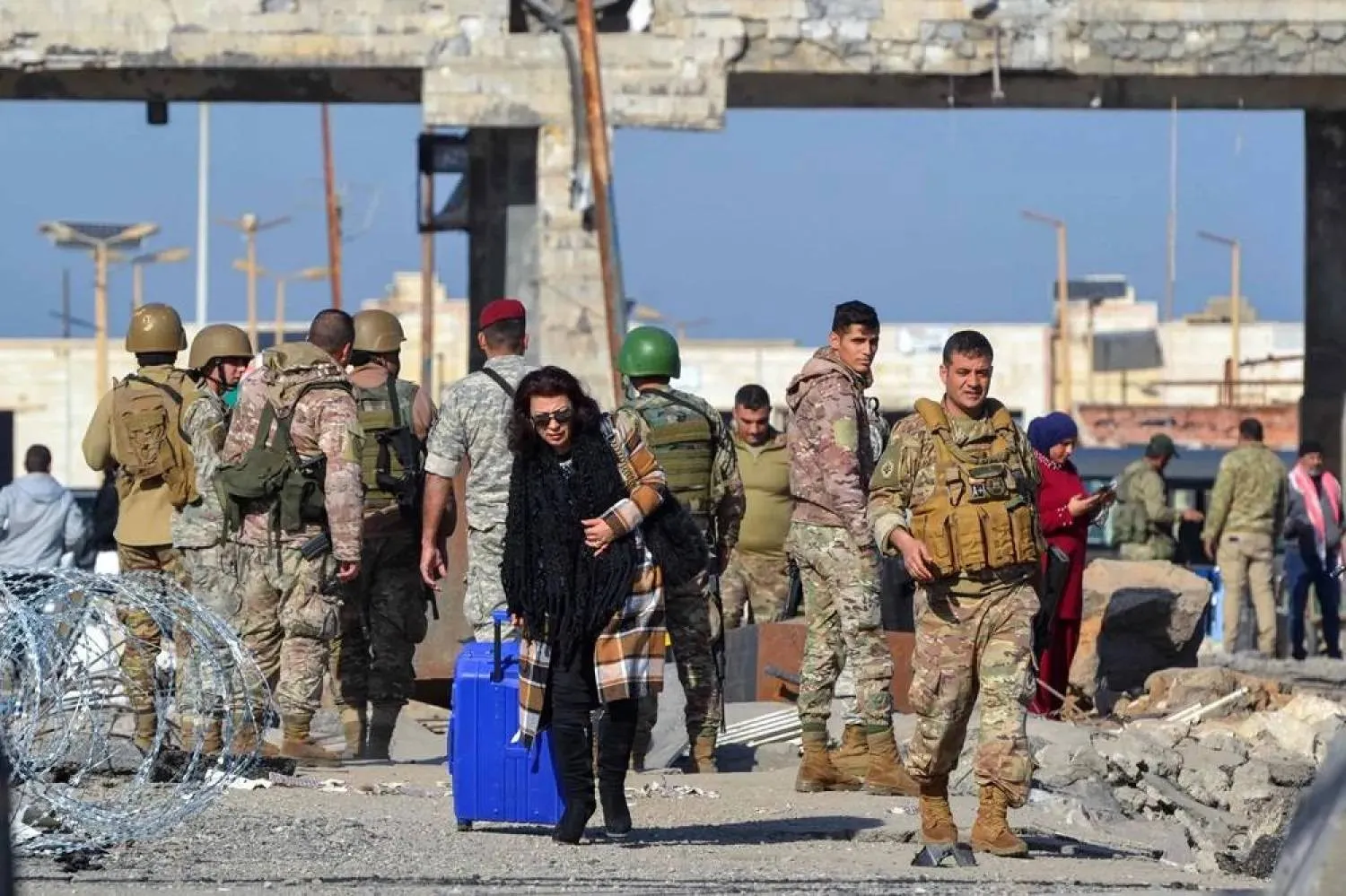 A woman arriving from Syria walks with her luggage into Lebanon through the northern crossing of Al-Arida on December 10, 2024. (AFP)