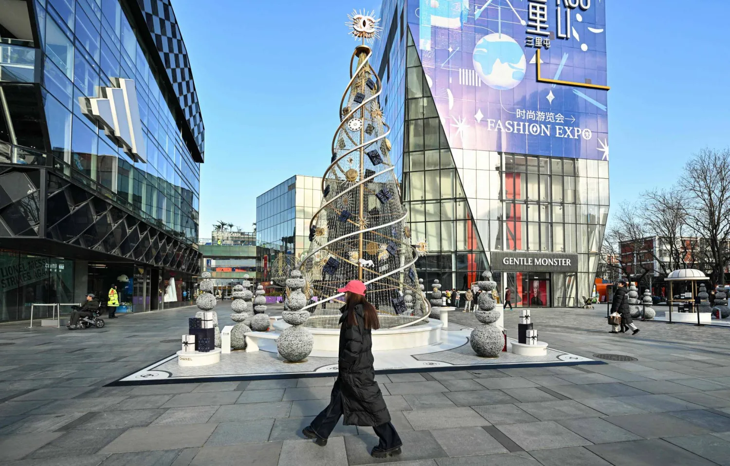  People walk past a Christmas tree at the Taikoo Li shopping center in Beijing on December 24, 2025. (AFP)