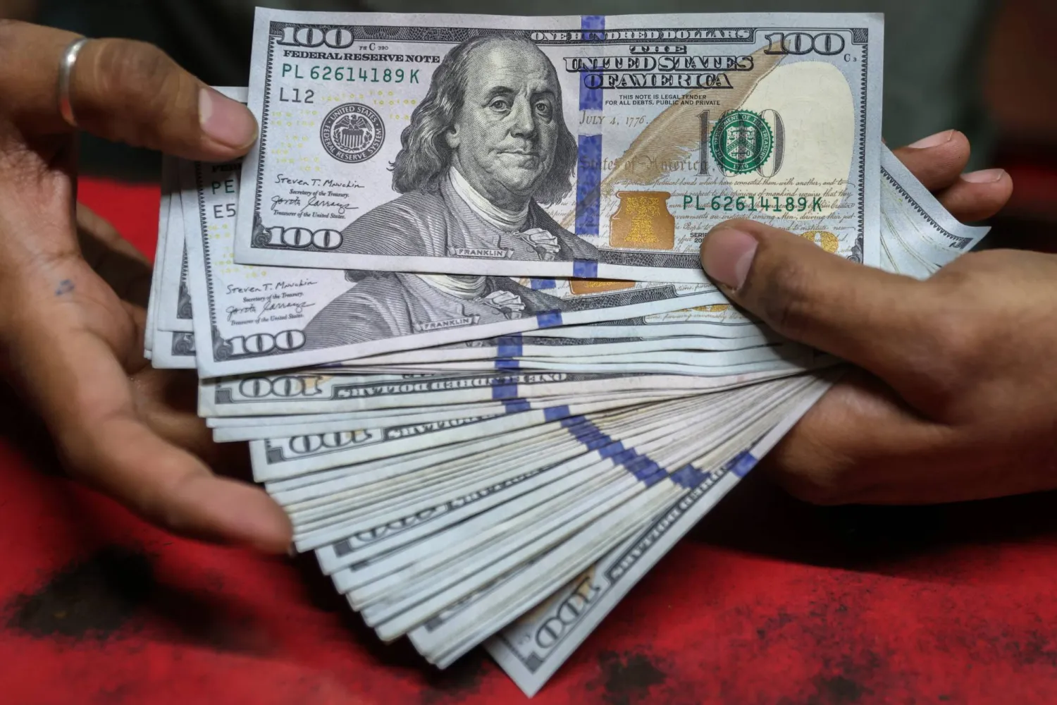 يعرض أحد مكاتب الصرافة في مومباي أوراق نقدية من فئة 100 دولار أميركي (إ.ب.أ)