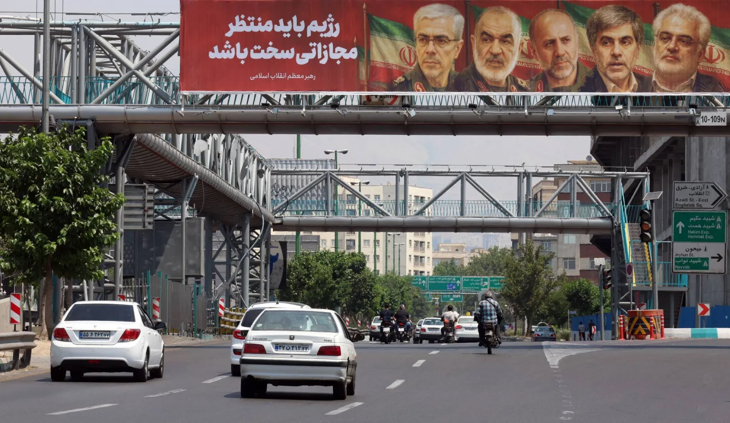 A poster shows slain members of the Iranian Revolutionary Guards Corps, who were killed in the June war, over a highway in Tehran on June 14.