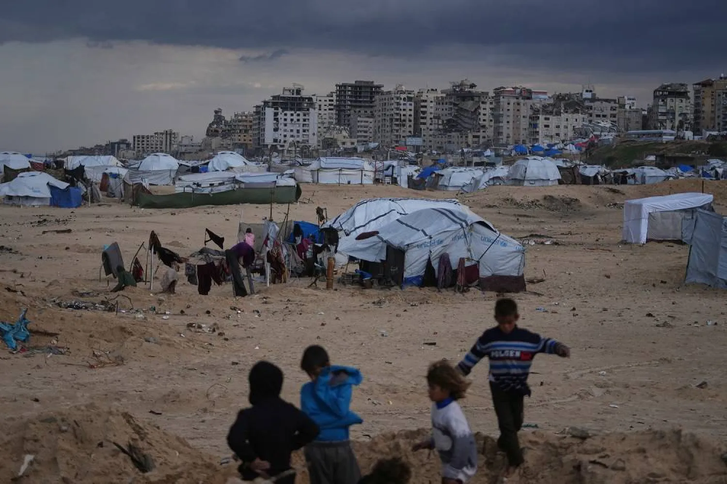 Palestinian children play next to tents in a makeshift camp for displaced people set up on the beach in Gaza City, Tuesday, Dec. 16, 2025. (AP)