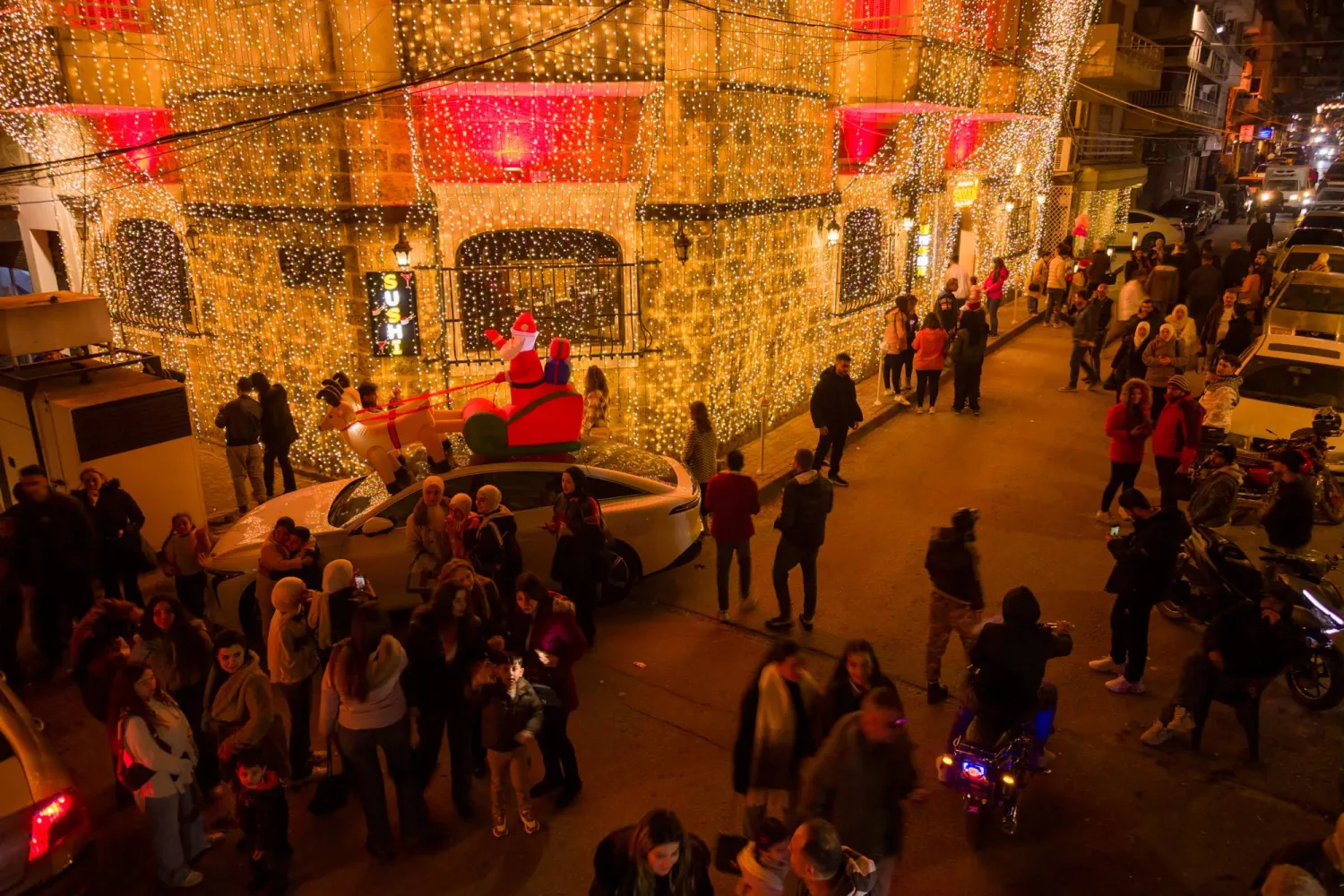 المارة في شارع مزين خلال احتفالات عيد الميلاد في اللاذقية الخميس بعد عام من فرار بشار الأسد وسيطرة المعارضة السورية على البلاد (إ.ب.أ)