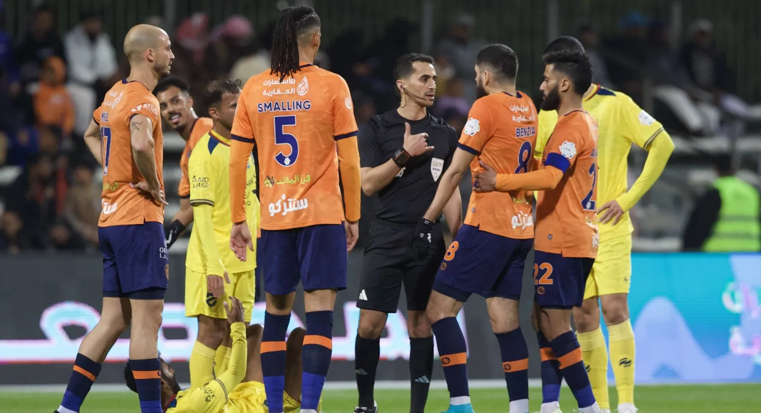 الحكم الزهراني في نقاش مع لاعبي الفريقين بعد إحدى الحالات (تصوير: نايف العتيبي)