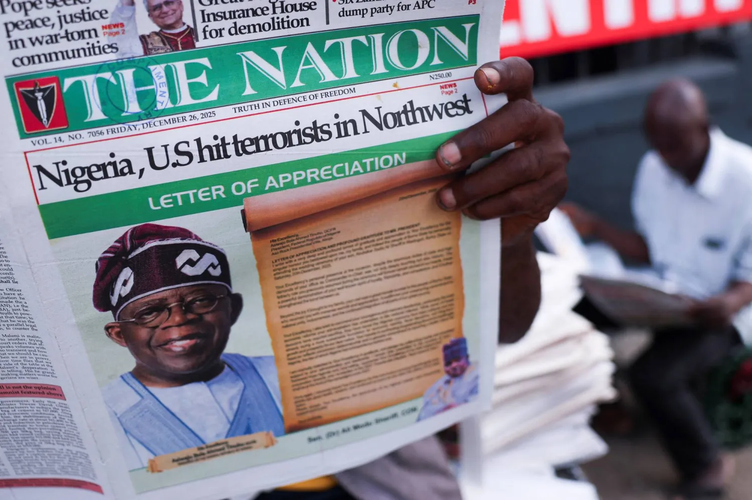 يقرأ الناس الصحف التي تنشر أخباراً عن الغارات الجوية الأميركية على مقاتلي تنظيم «داعش» - لاغوس - نيجيريا - 26 ديسمبر 2025 (رويترز)