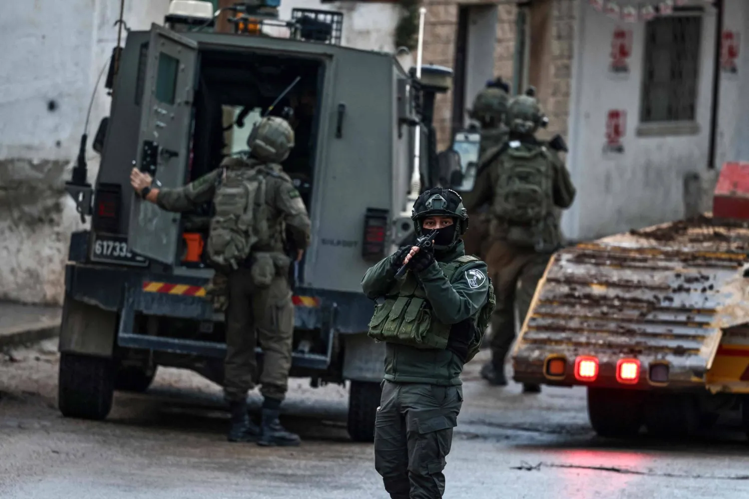 Israeli security forces secure a street as they leave the Palestinian village of Bizariya, in the occupied West Bank, where Israeli authorities demolished the house of a Palestinian man killed in July after he and another man reportedly killed an Israeli settler on the same day, on December 24, 2025. (AFP)