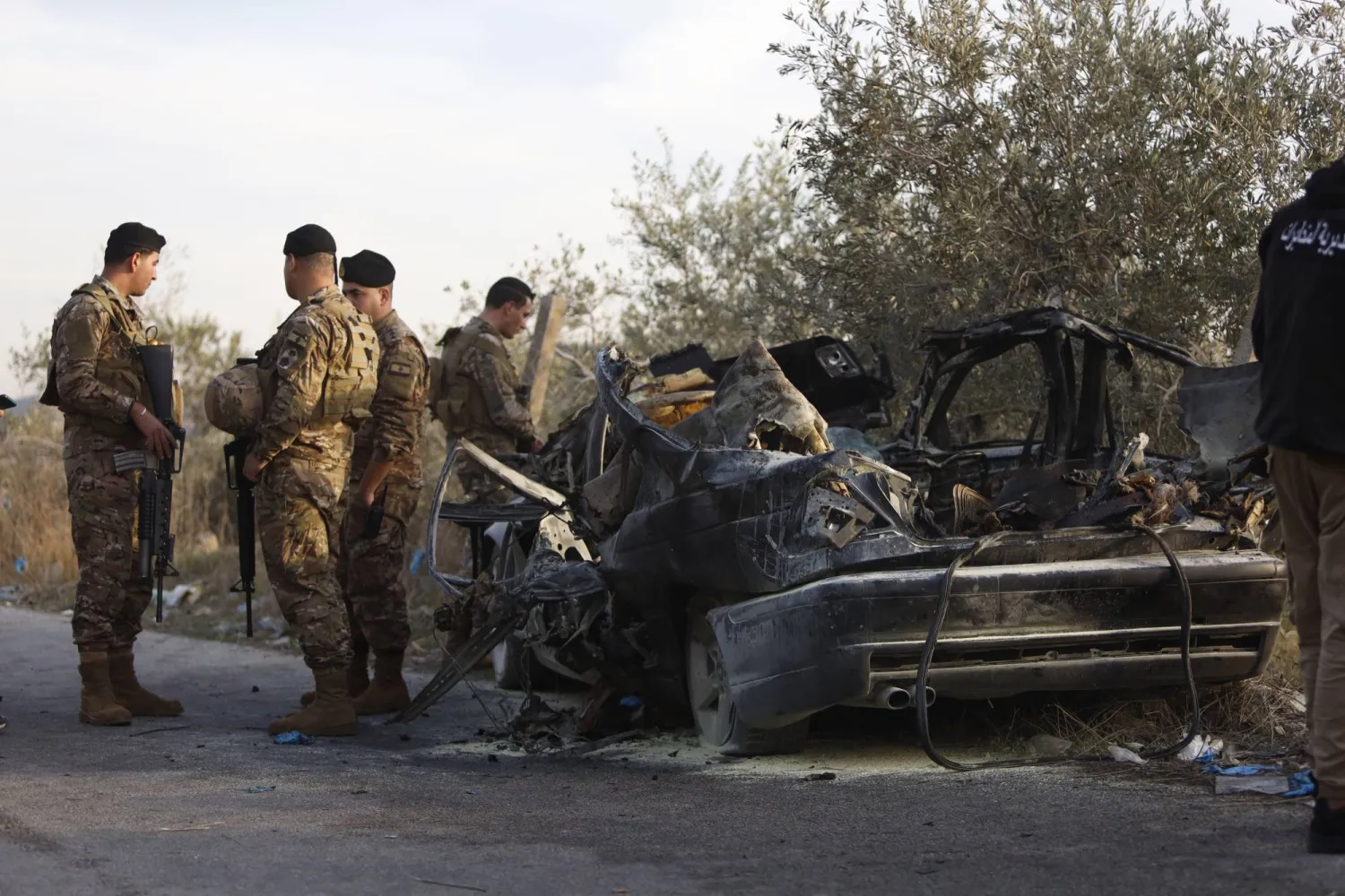 عناصر في الجيش اللبناني يقفون قرب سيارة استهدفتها غارة إسرائيلية في بلدة عقتنيت بجنوب لبنان وأسفرت عن مقتل 3 أشخاص (د.ب.أ)