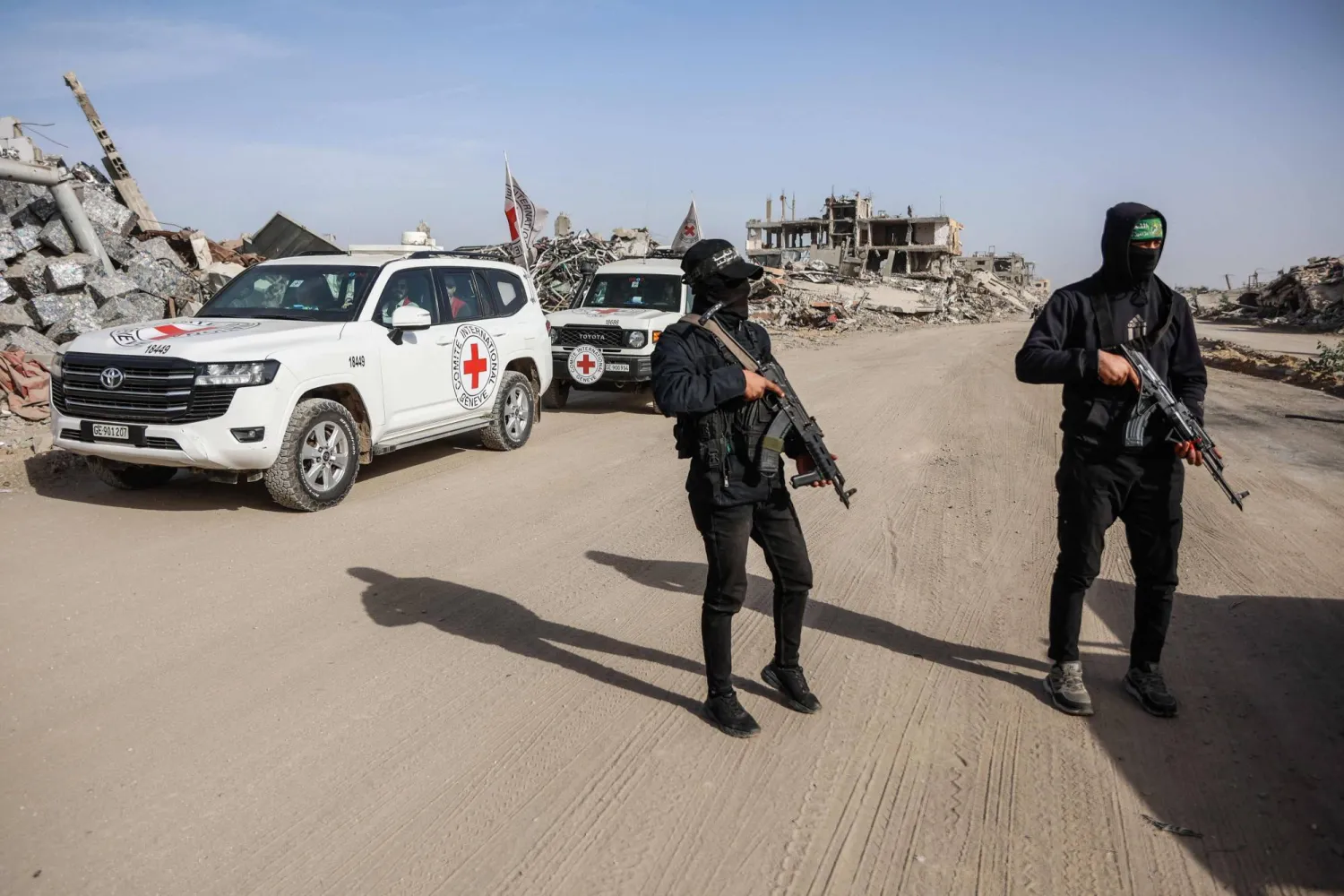 Palestinian Hamas members secure the area as Egyptian workers accompanied by members of the International Committee of the Red Cross (ICRC) search for the remains of the last Israeli hostage in the Zeitoun neighborhood of Gaza City on December 8, 2025. (Photo by Omar AL-QATTAA / AFP)