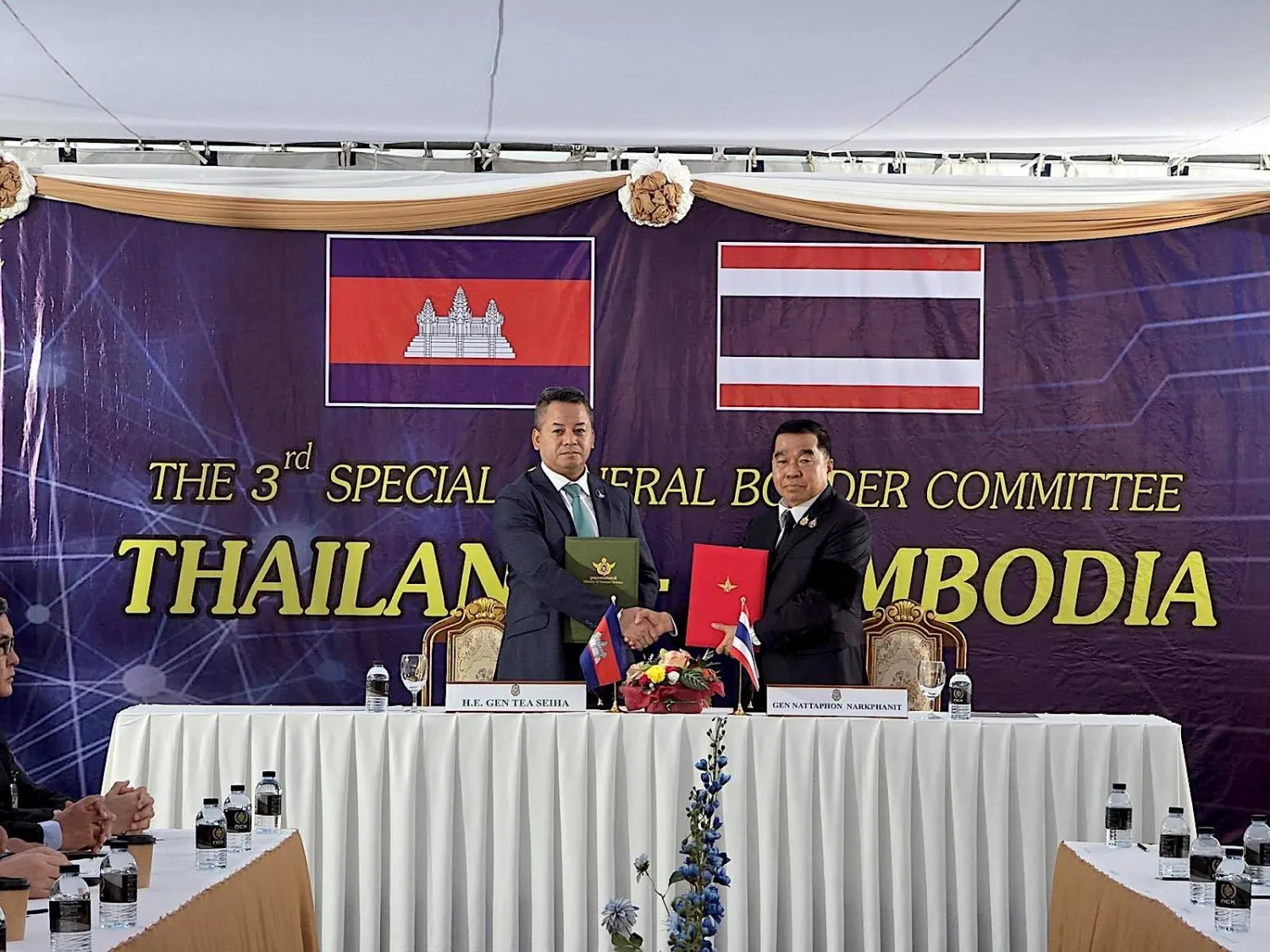 A handout photo made available by the Defense Ministry of Thailand shows Cambodian Defense Minister Tea Seiha (L) and Thai Defense Minister Natthaphon Narkphanit exchanging ceasefire agreement documents during a General Border Committee Meeting in Ban Pak Kard, Chanthaburi Province, Thailand, 27 December 2025. (EPA/Defense Ministry of Thailand/Handout)
