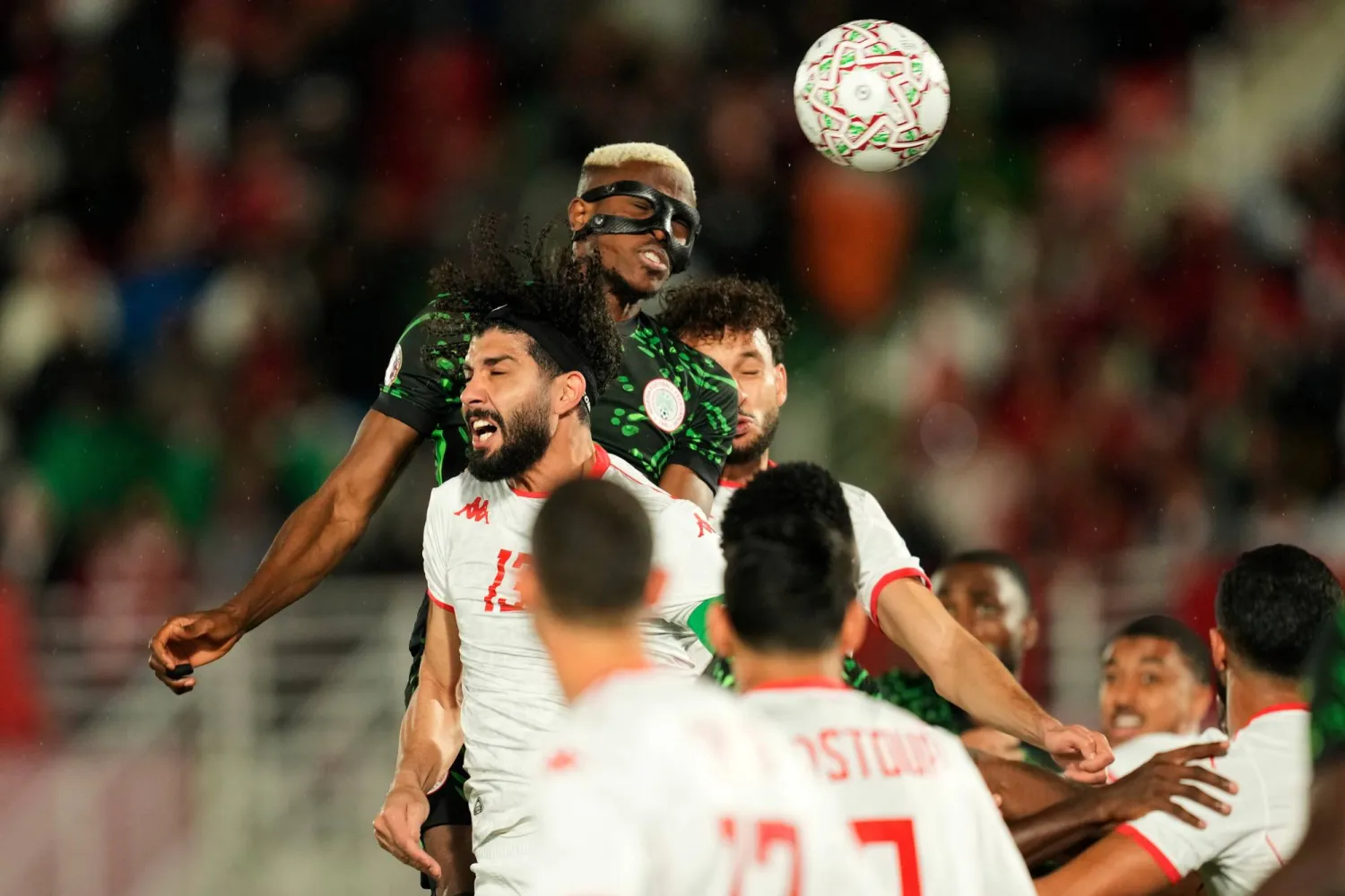 Nigeria's Victor Osimhen, top, wins a header against Tunisia's Ferjani Sassi during the Africa Cup of Nations group C soccer match between Nigeria and Tunisia in Fez, Morocco, Saturday, Dec. 27, 2025. (AP Photo/Mosa'ab Elshamy)