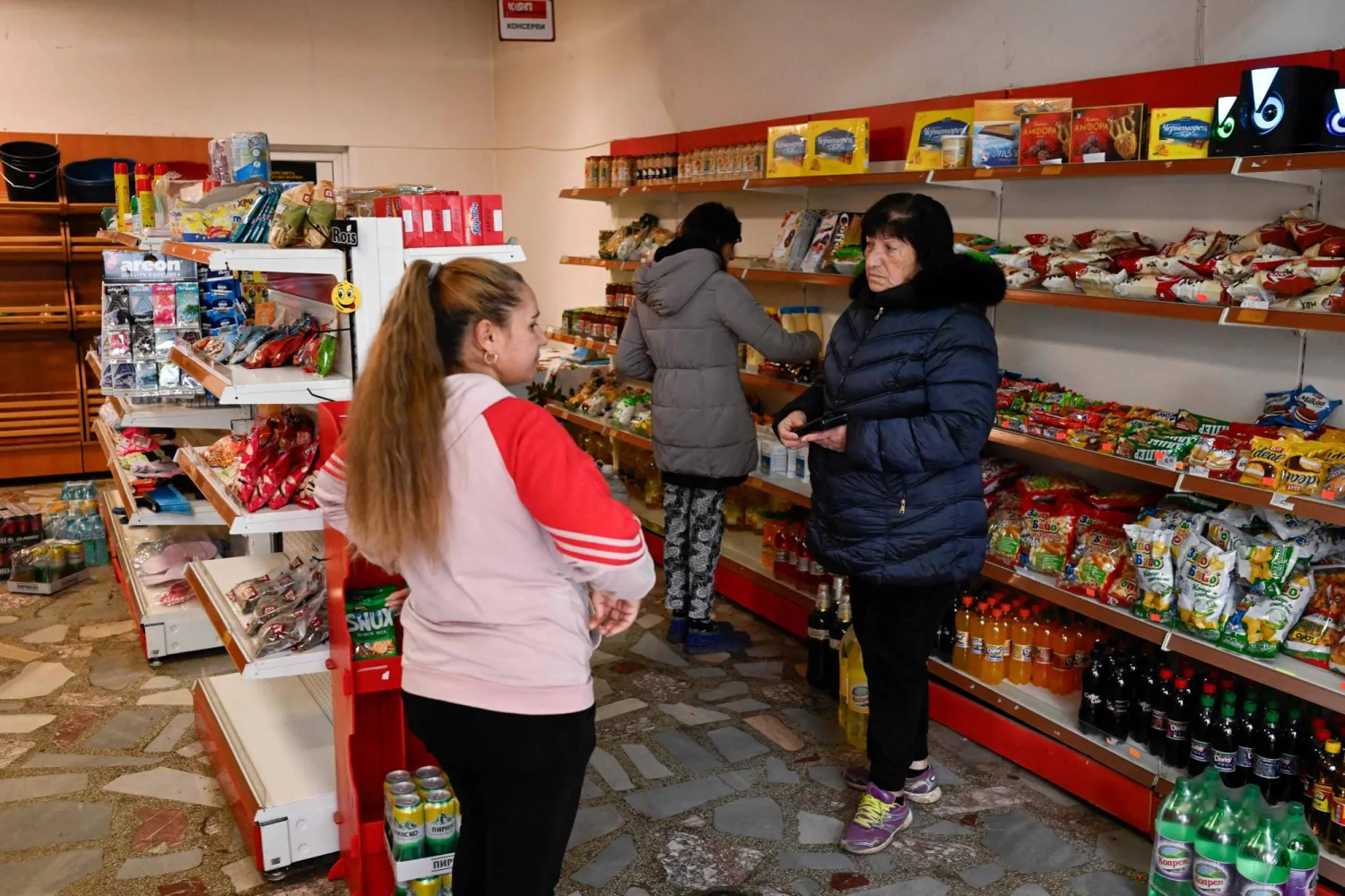 Customers shop in a grocery store in the village of Chuprene, northwestern Bulgaria on December 7, 2025. (Photo by Nikolay DOYCHINOV / AFP)