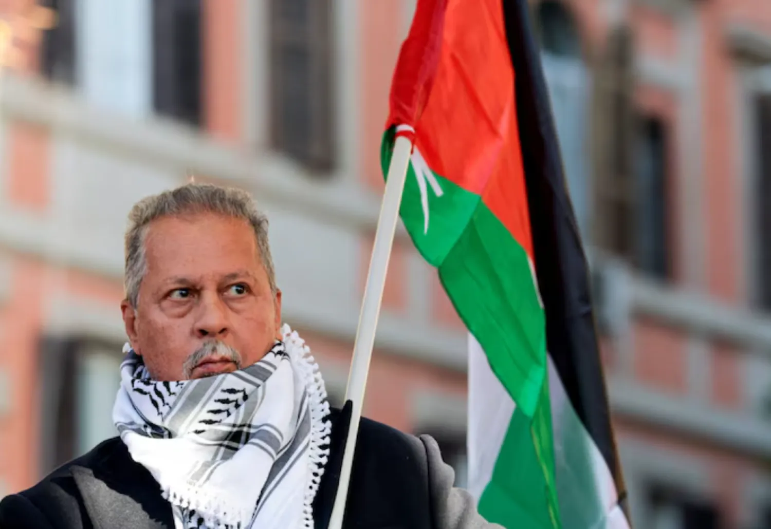 President of the Palestinian Association in Italy, Mohammad Hannoun, carries a Palestinian flag during a nationwide strike, called by the USB union, in solidarity with Gaza and against the government and its plan to increase military spending, in Rome, Italy, November 29, 2025. Italian Interior Minister Matteo Piantedosi said Mohammad Hannoun is among nine people arrested on December 27 on suspicion of financing Hamas through charities based in Italy, in an operation coordinated by anti-mafia and anti-terrorism units. in Italy. REUTERS/Remo Casilli 