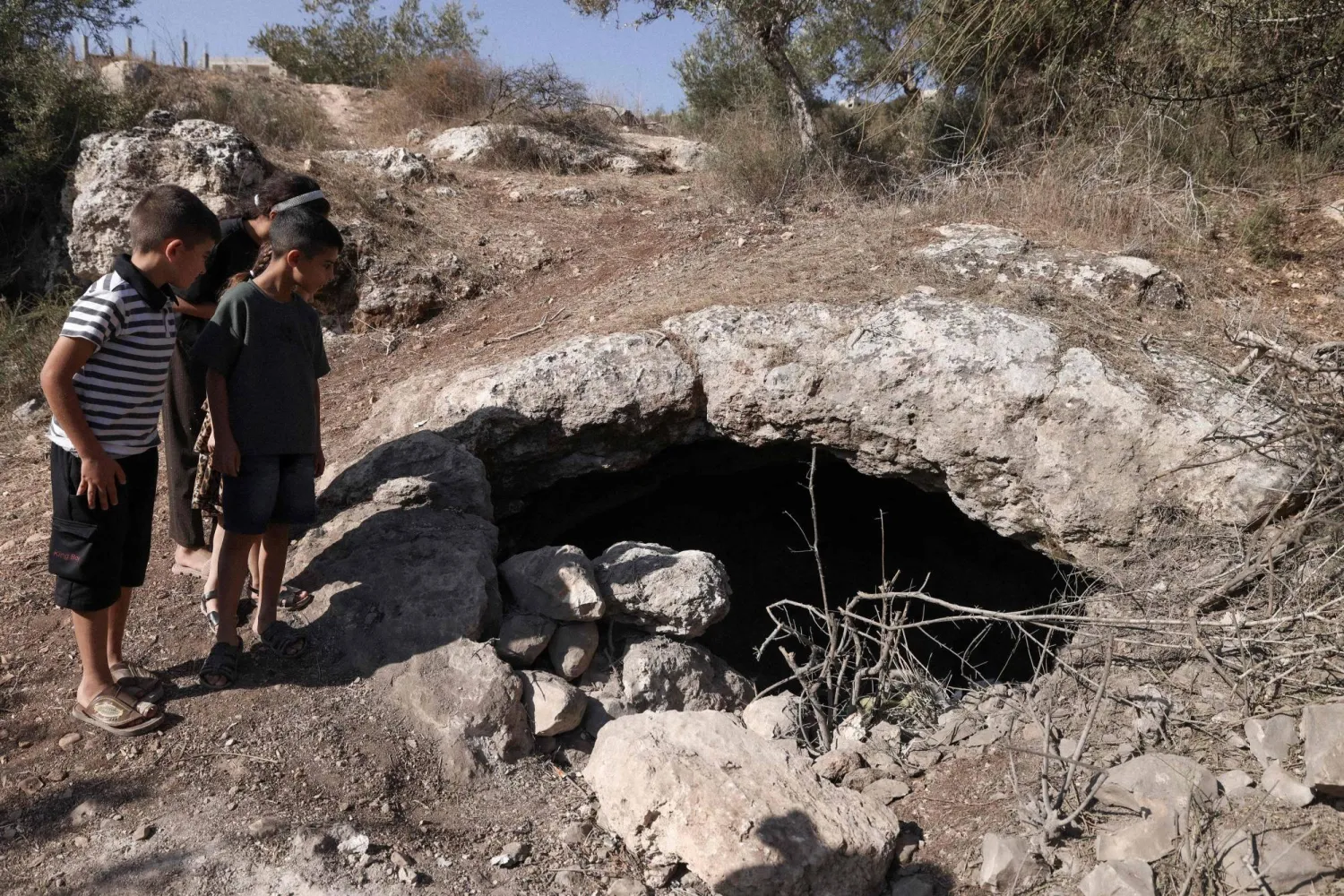 صبية فلسطينيون ينظرون إلى كهف قُتل فيه 3 شبان على يد القوات الإسرائيلية قرب مدينة جنين بالضفة الغربية أكتوبر الماضي (أ.ف.ب)