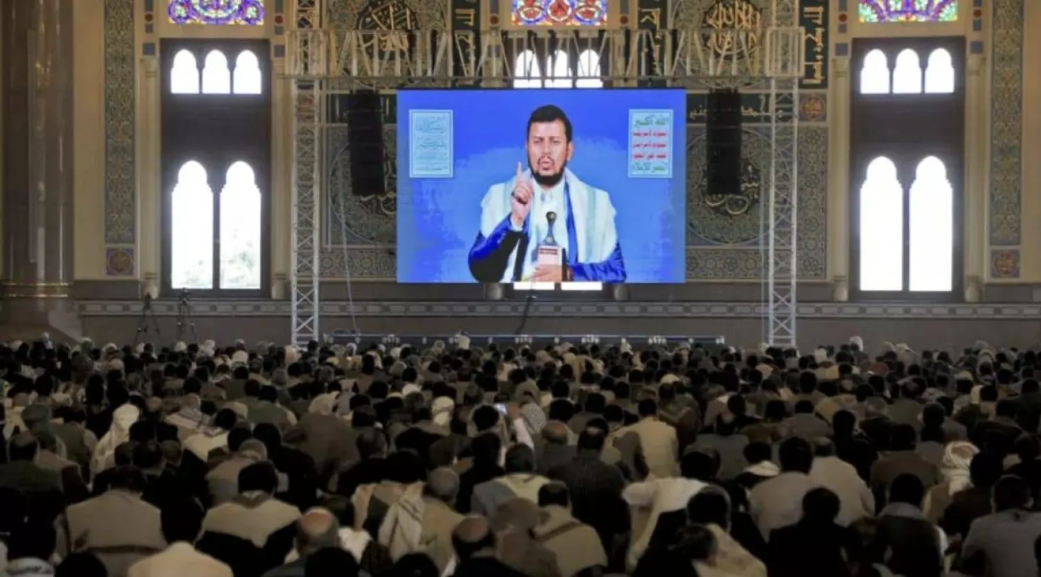عناصر حوثيون يستمعون إلى زعيمهم عبد الملك الحوثي بقاعة في صنعاء عبر البث التلفزيوني (أ.ف.ب)