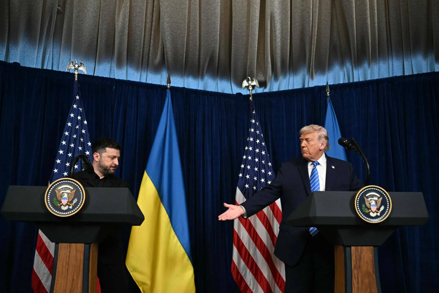 ترمب يمد يده لمصافحة نظيره الأوكراني فولوديمير زيلينسكي خلال مؤتمر صحافي عقب محادثات في مقر إقامته في بالم بيتش (ا.ف.ب)