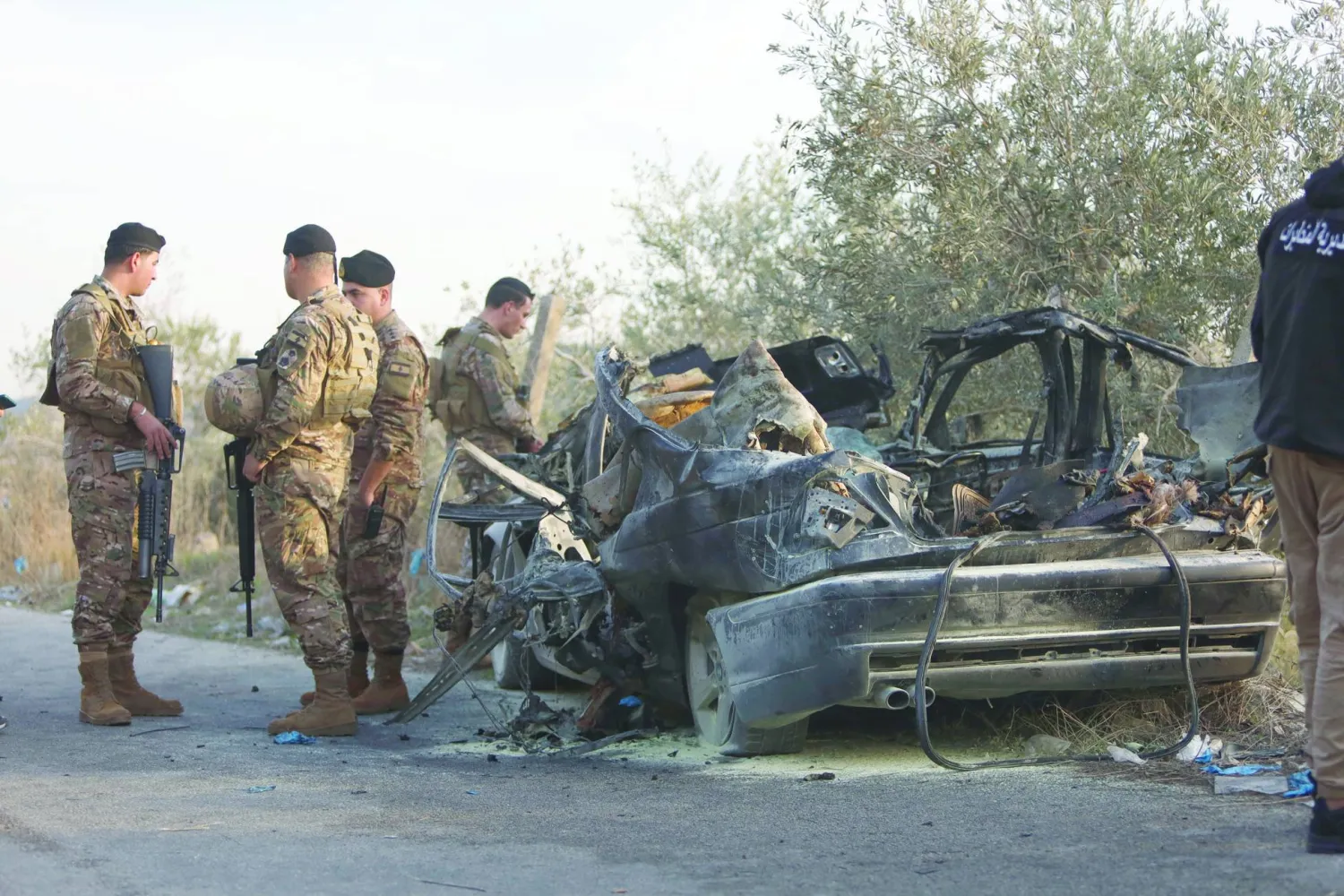 عناصر في الجيش اللبناني يقفون قرب سيارة استهدفتها غارة إسرائيلية في بلدة عقتنيت بجنوب لبنان وأسفرت عن مقتل 3 أشخاص (د.ب.أ)