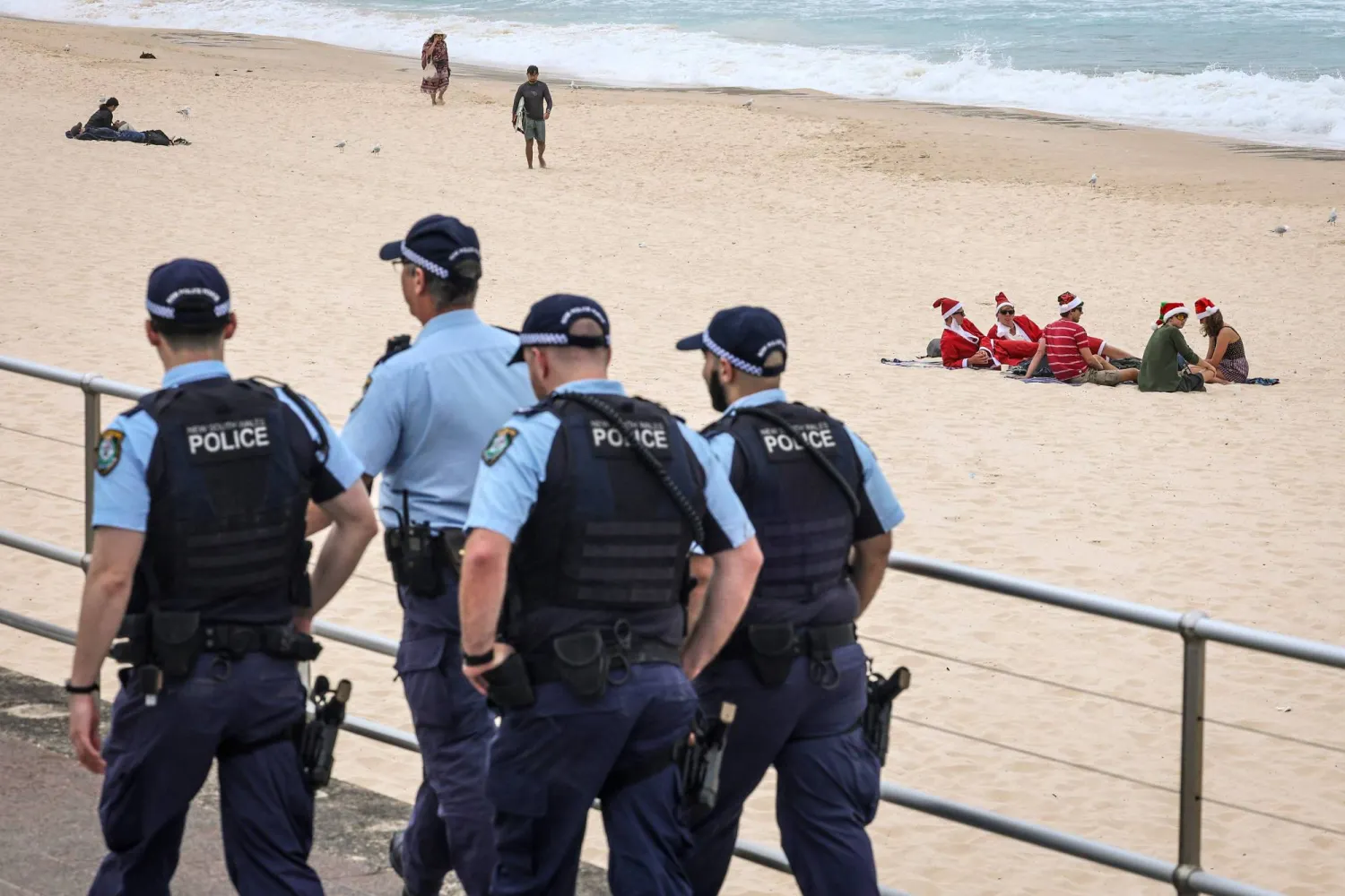 Police officers patrol near beachgoers on Christmas Day at Bondi Beach in Sydney on December 25, 2025. (AFP)