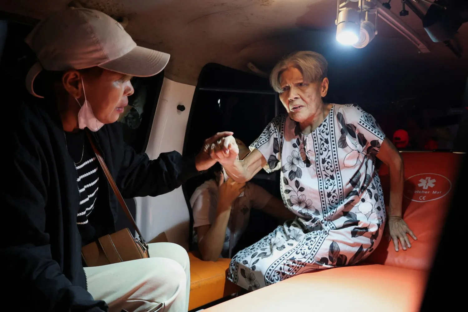 سكان محليون ينقذون امرأة مُسنة أثناء حريق في دار ويردها داماي للمسنين بمانادو مقاطعة سولاويزي الشمالية بإندونيسيا (رويترز)